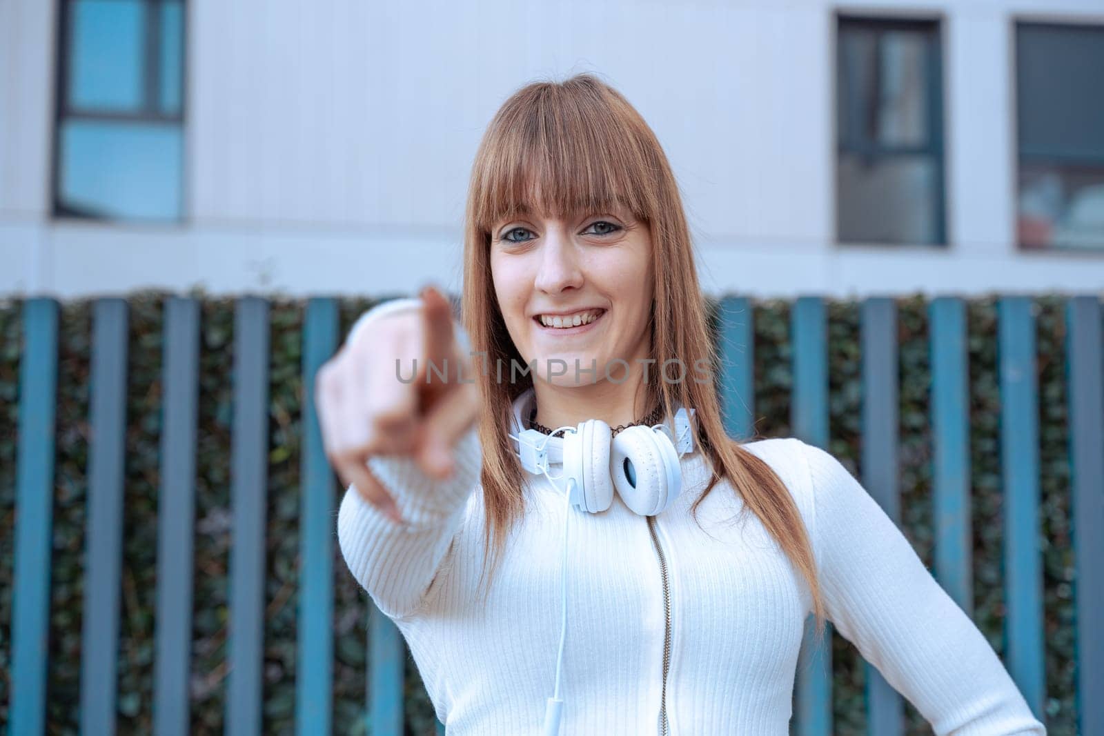 Young caucasian woman pointing her finger in front looking at the camera. Woman Showing Signs.
