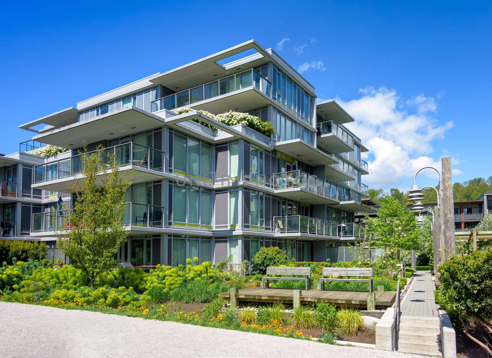 A perfect neighborhood. Pathway in residential park between the buildings on bright sunny day