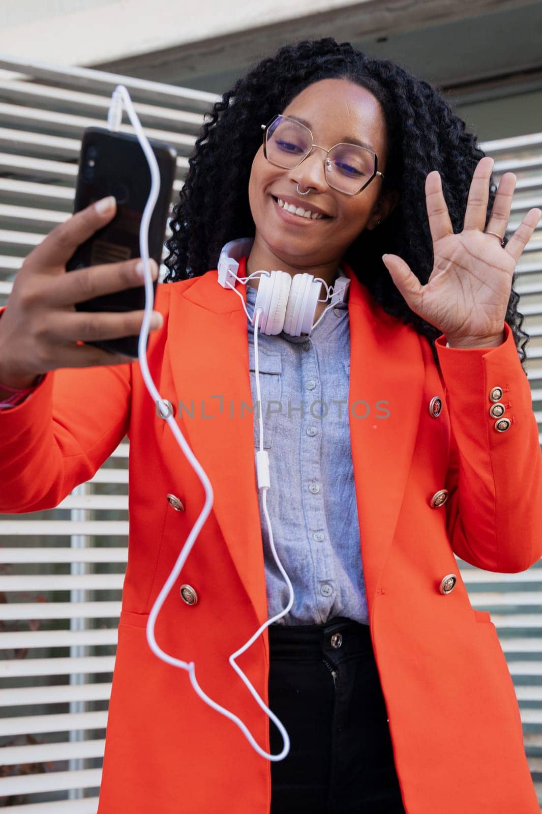 vertical photo of A young black businesswoman making a mobile phone video call with a business colleague.