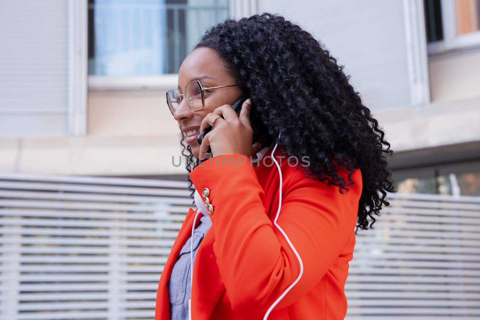 Beautiful happy black business woman talking on mobile phone outdoors. Girl talking on mobile phone