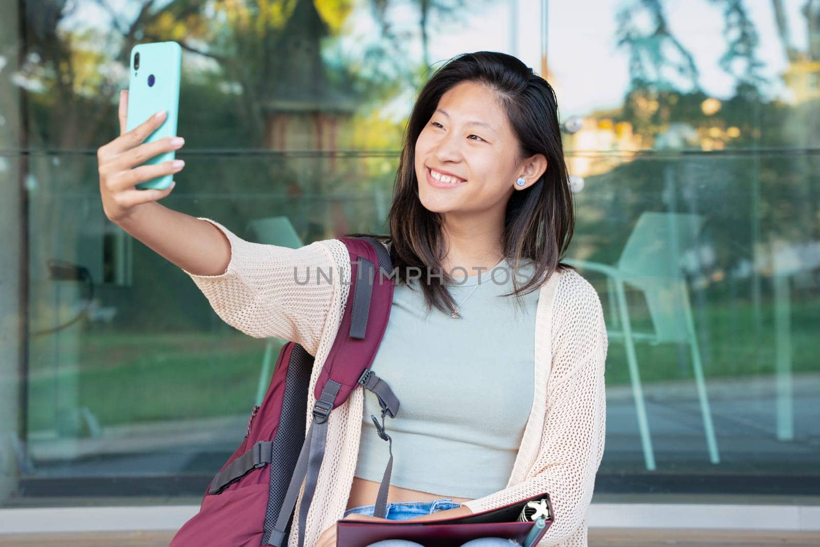Happy young chinese taking a selfie with smartphone