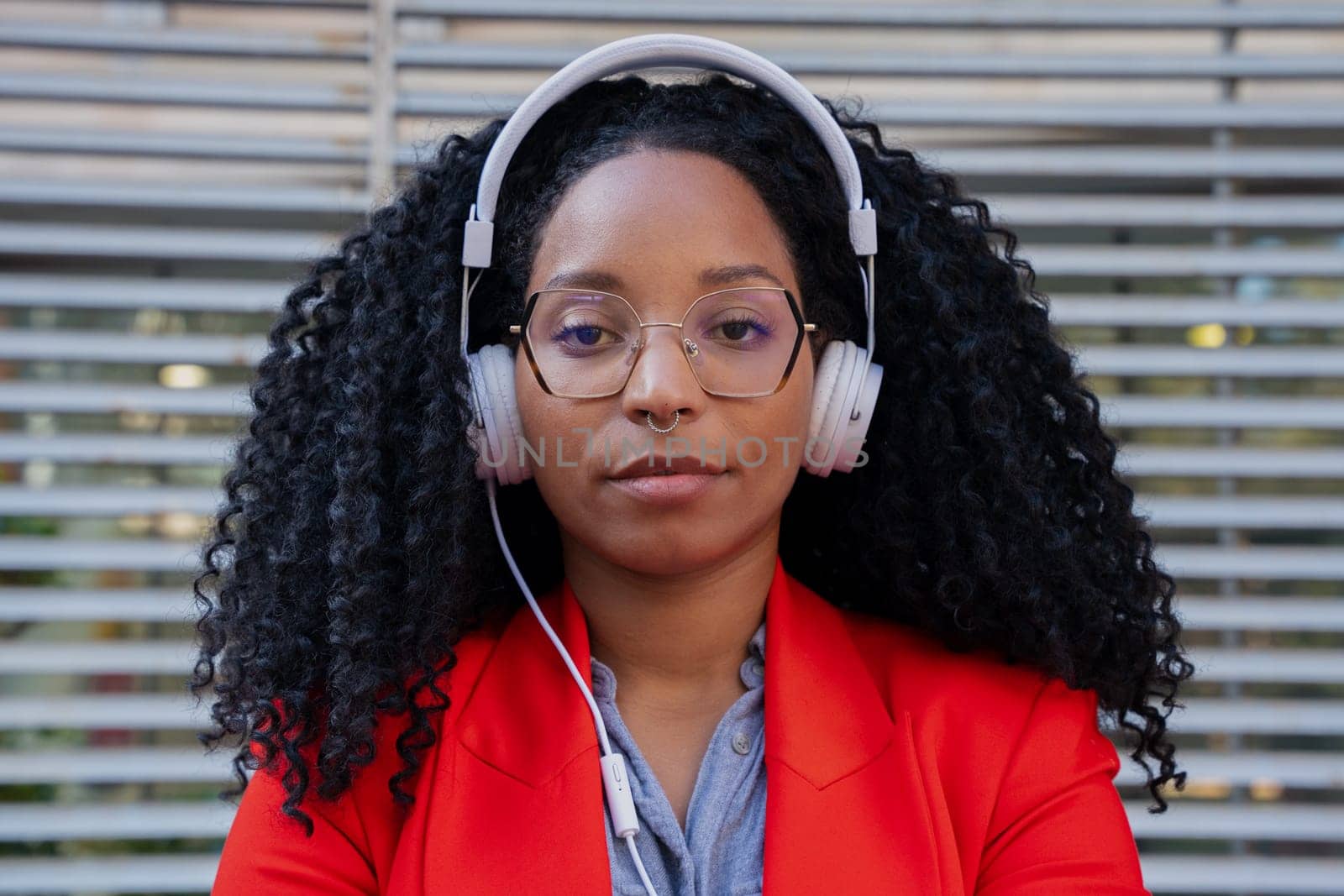 Thoughtful young woman with headphones looking at camera. Front view of a black woman Head shot of a proud businesswoman