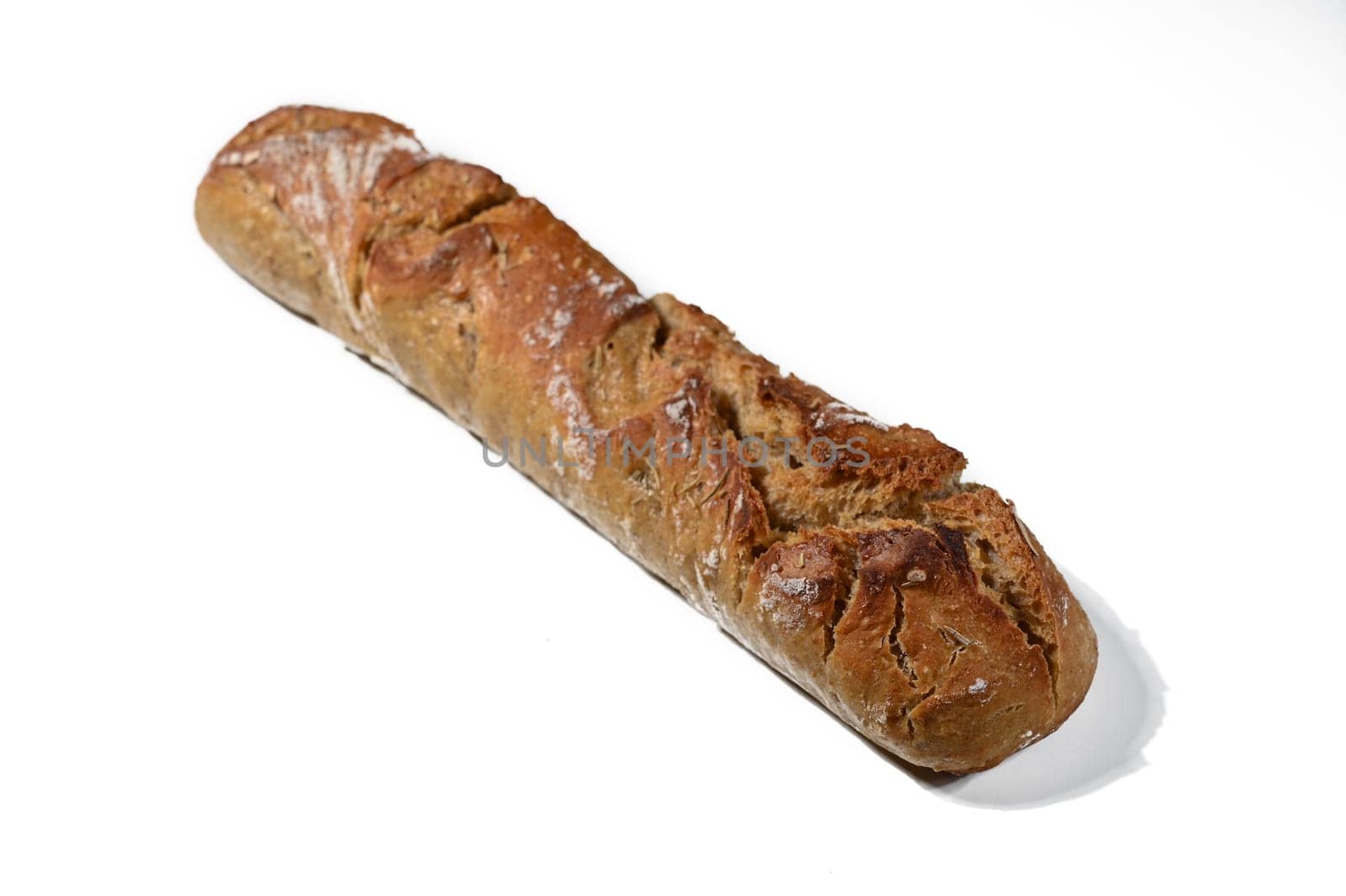 Rustic bread with a golden crust sits invitingly on a white surface, celebrating its delicious aroma and texture.