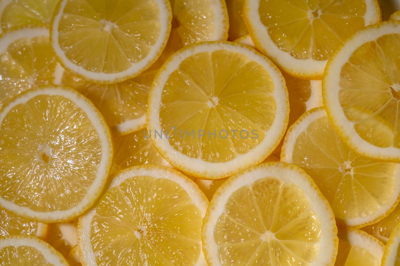 Freshly cut lemon slices showcase their zesty texture, inviting taste and color in a warm, sunlit setting.