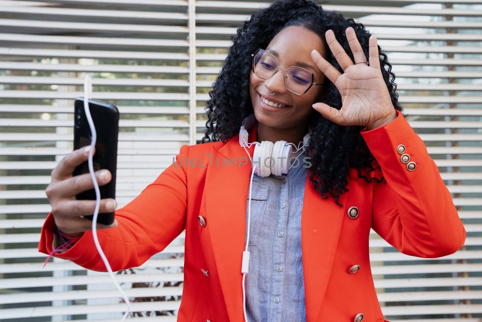 A young black businesswoman making a video call on the mobile phone with a business colleague.