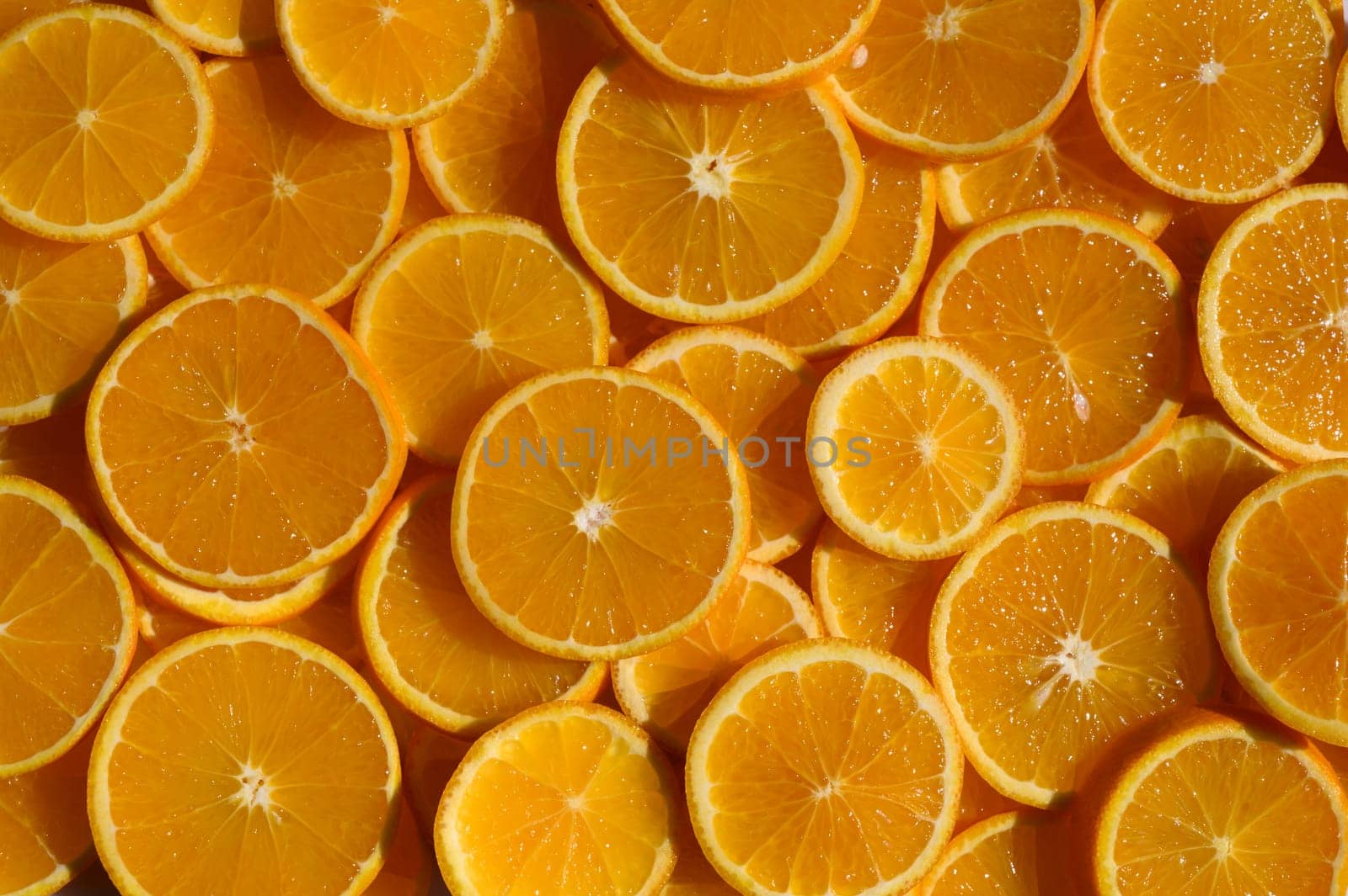 Juicy orange slices lie side by side, creating a burst of color and freshness perfect for a summer gathering.