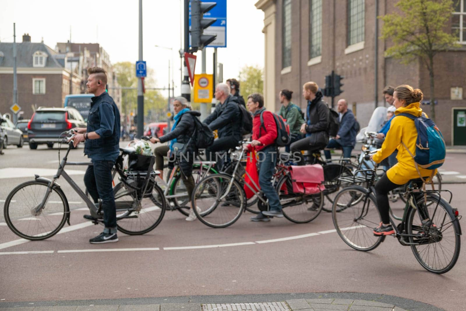 AMSTERDAM, THE NETHERLANDS - APRIL 16, 2019: The Cyclists on bicycles wait for a green traffic light