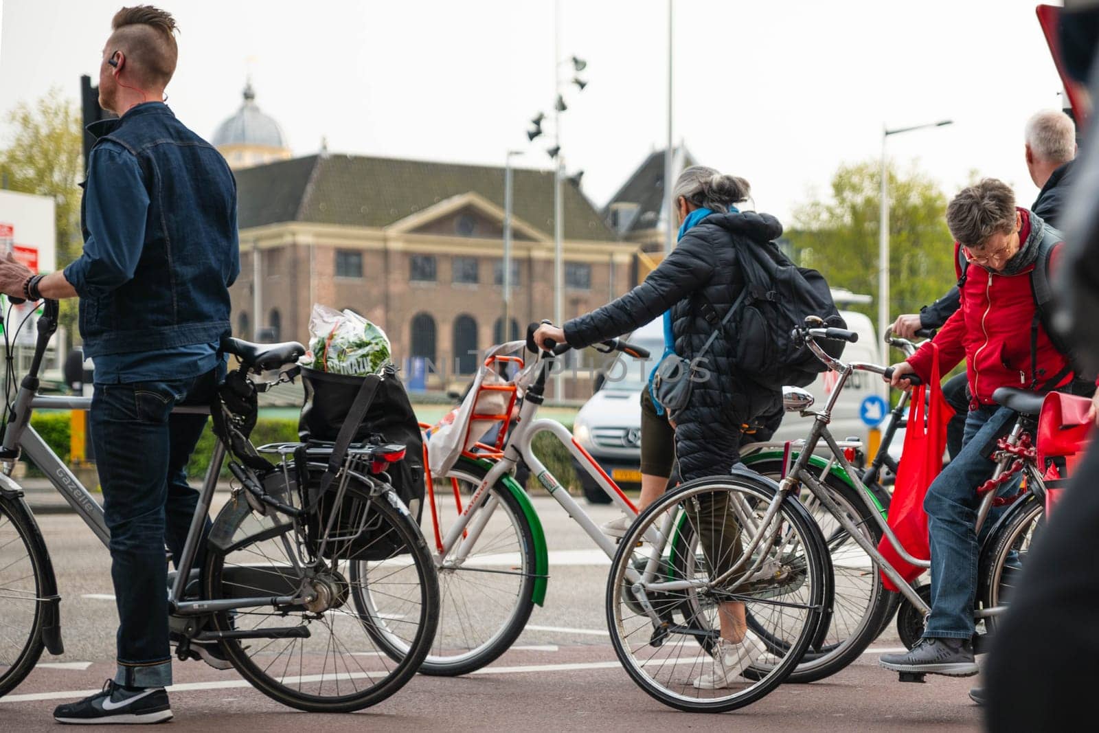AMSTERDAM, THE NETHERLANDS - APRIL 16, 2019: The Cyclists on bicycles wait for a green traffic light
