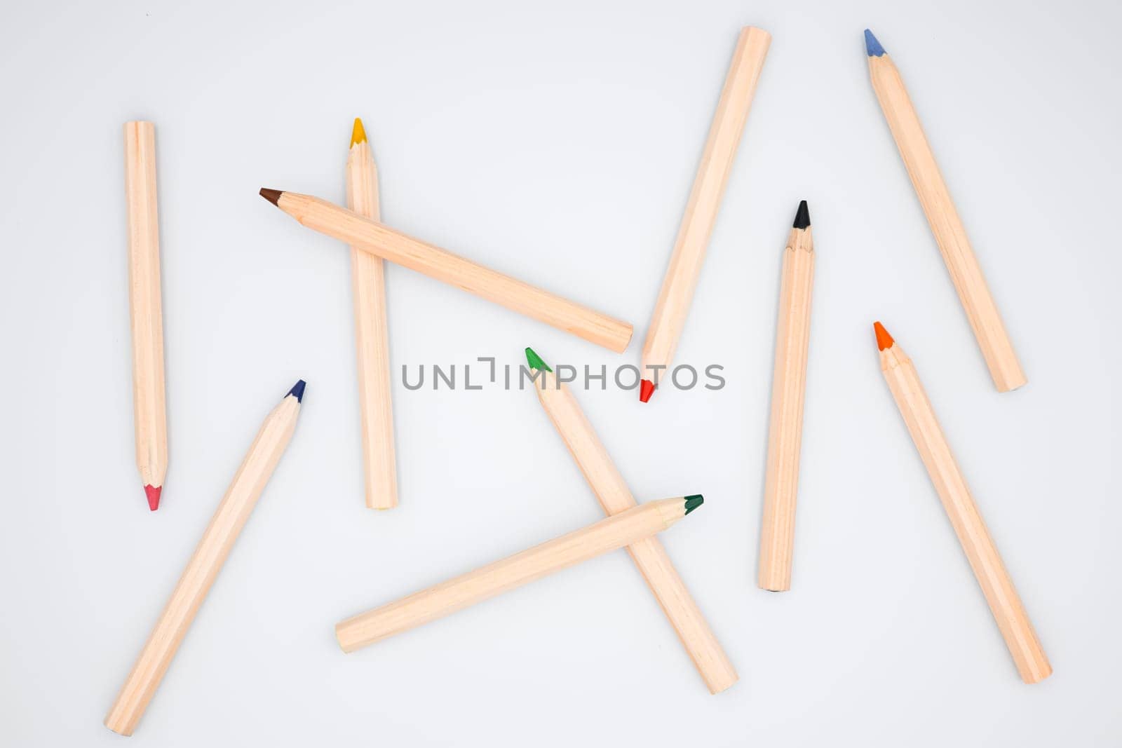 Assorted colored pencils on white background. Creative art supplies display.