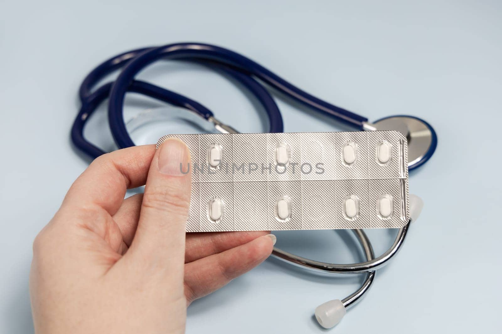 Female hands holding pills in blister. Prescription medication. High quality photo