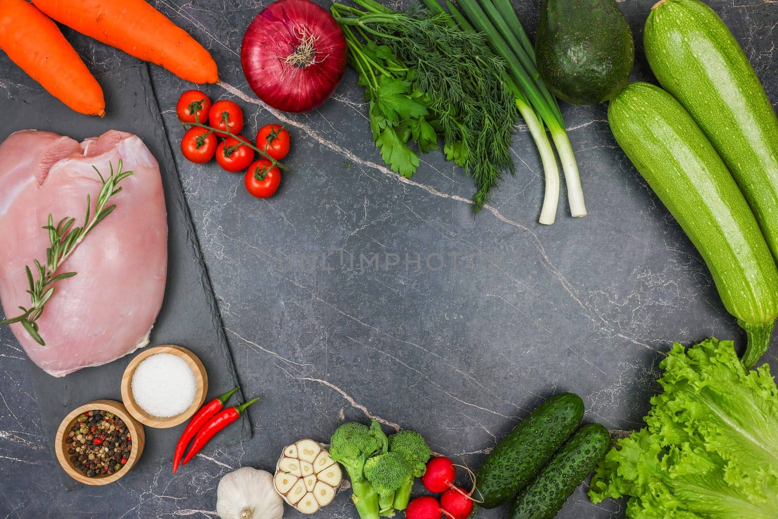 Raw turkey fillet with a sprig of rosemary, spices in wooden bowls, vegetables, root vegetables and herbs on a dark background with space for text. The concept of proper and healthy nutrition, diet, menu, natural and organic products. High quality photo