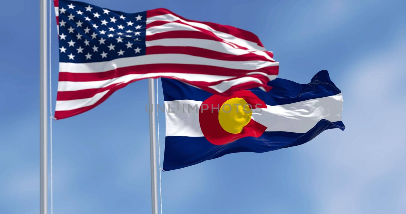 Colorado state flag waving with the national flag of the United States of America on a clear day. 3D illustration render. Rippled textile. Selective focus