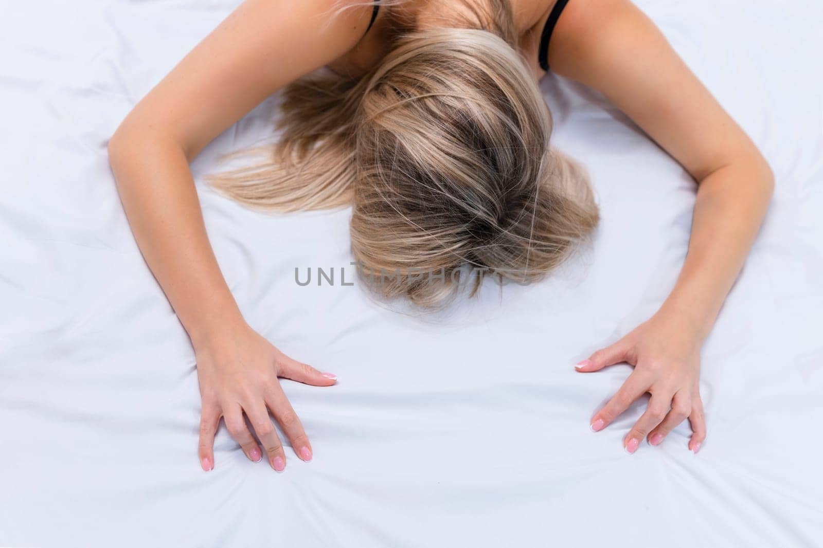 Female orgasm .A lonely sexy girl in her underwear lies on the bed on her face pleasure. Masturbation and oral sex.