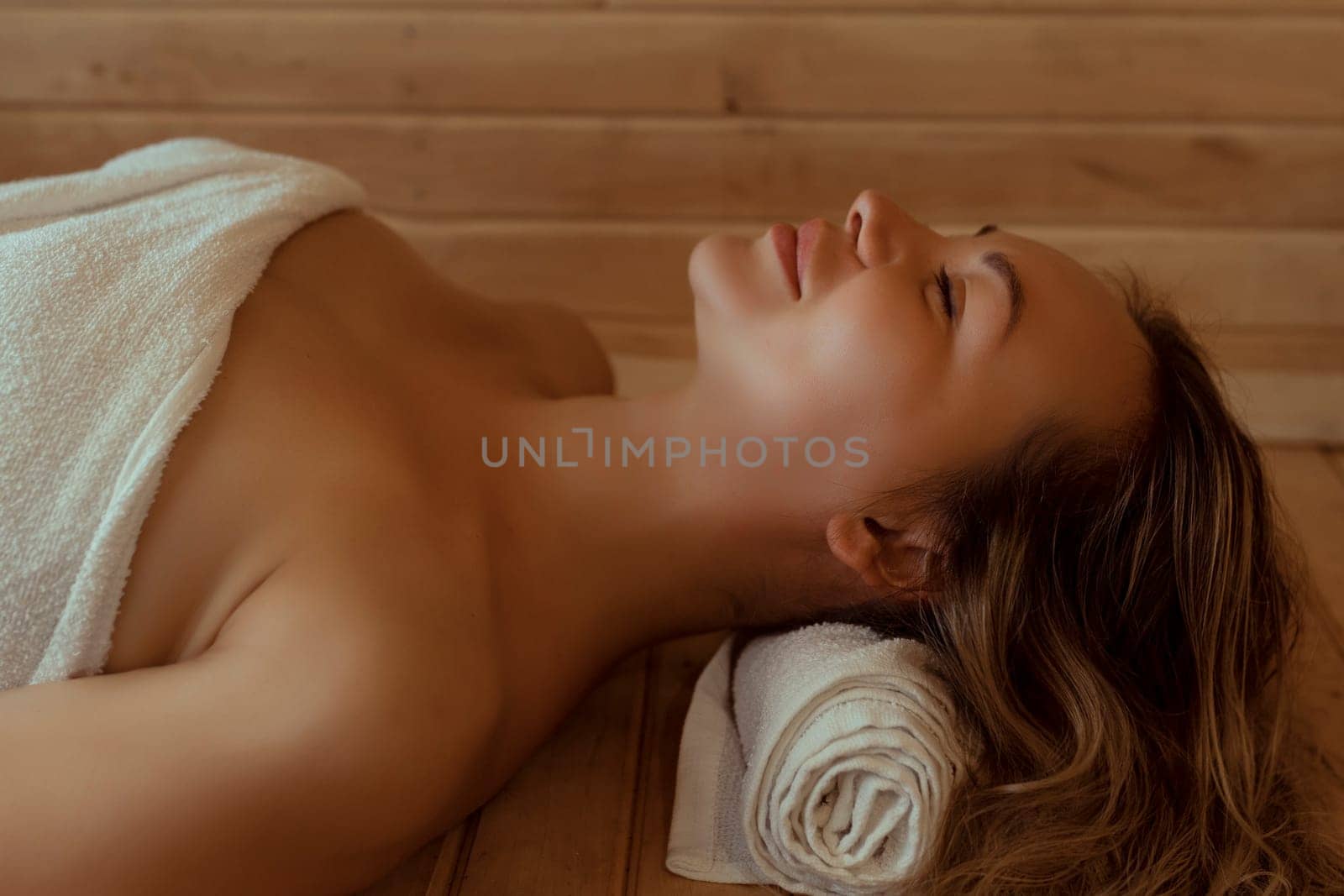 Beautiful young woman relaxing in Finnish sauna.