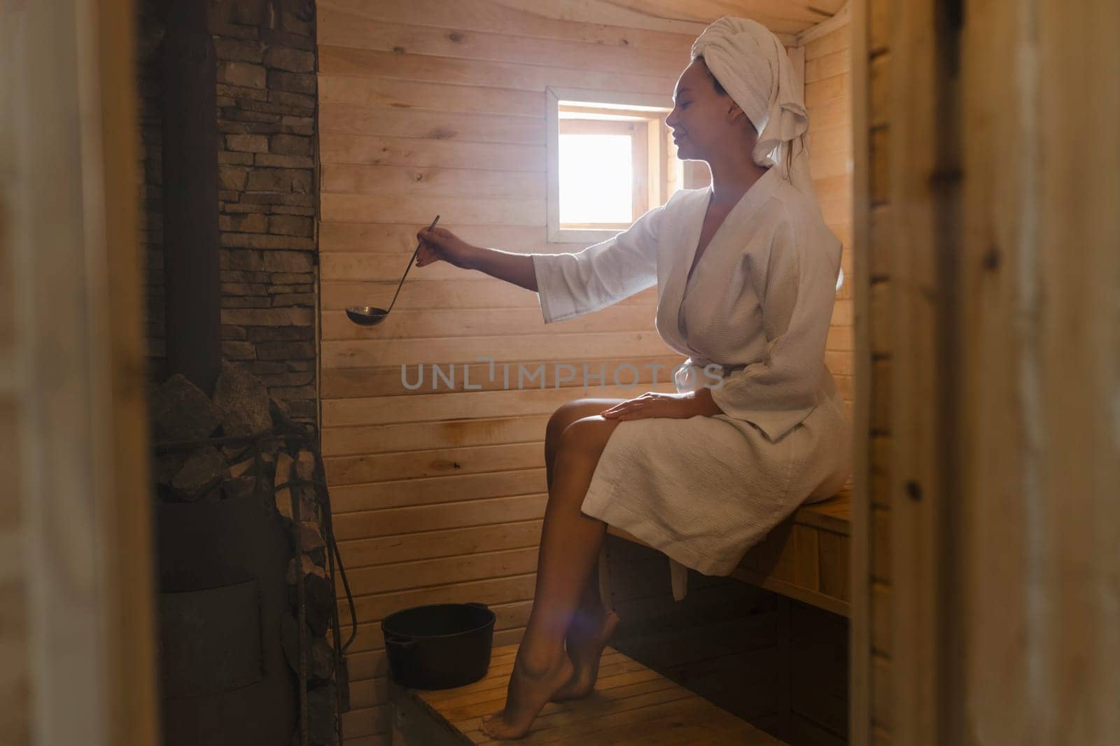 Beautiful young woman relaxing in Finnish sauna.