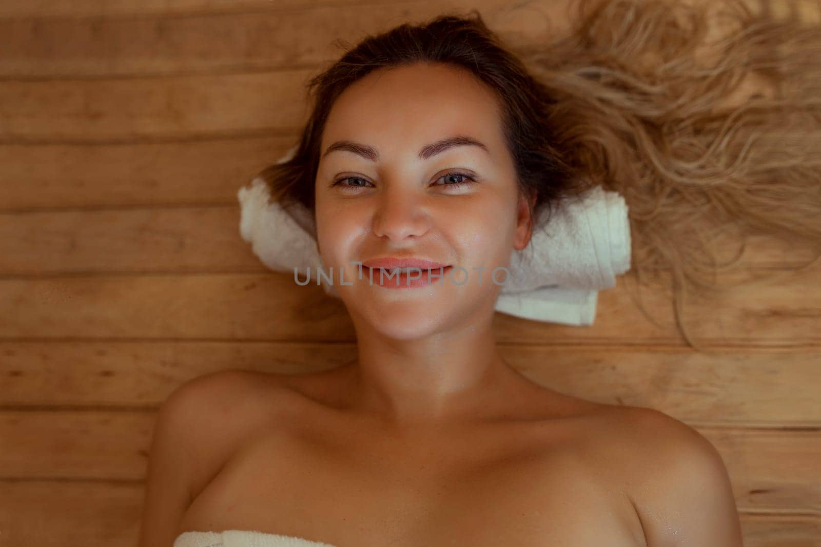 Beautiful young woman relaxing in Finnish sauna.