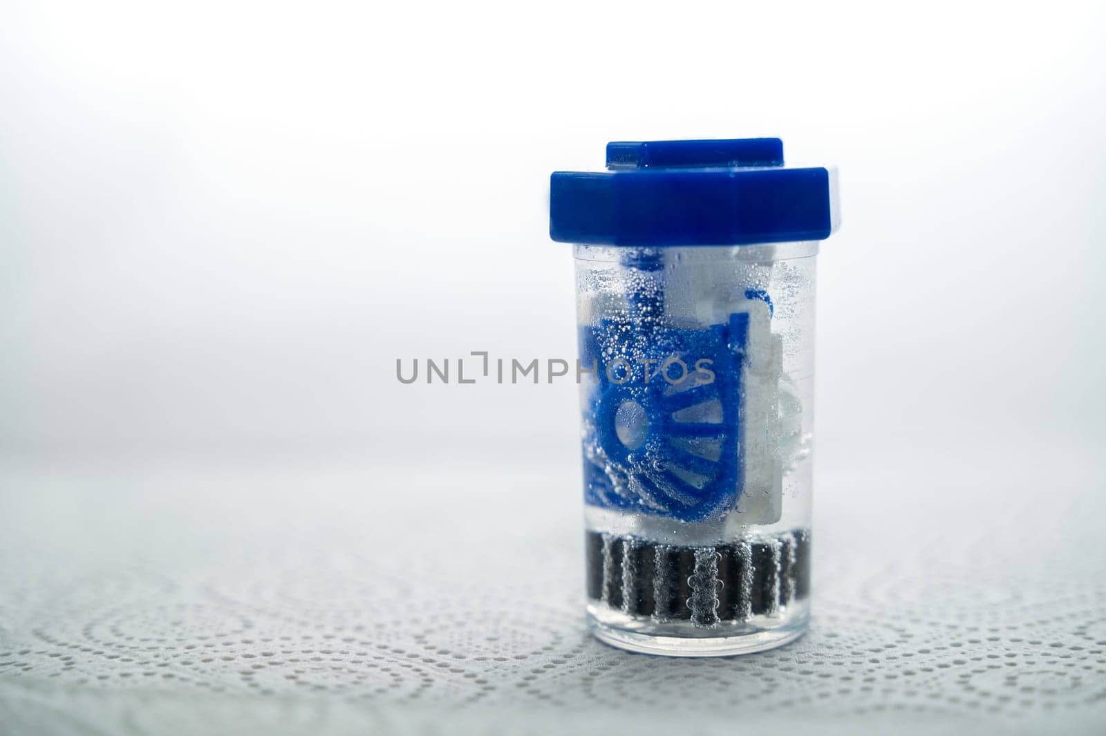 close-up of a container for cleaning and storing contact lenses for the eyes, used at home. For soft and hard lenses, in the container there is an active cleaning process, bubbles are released