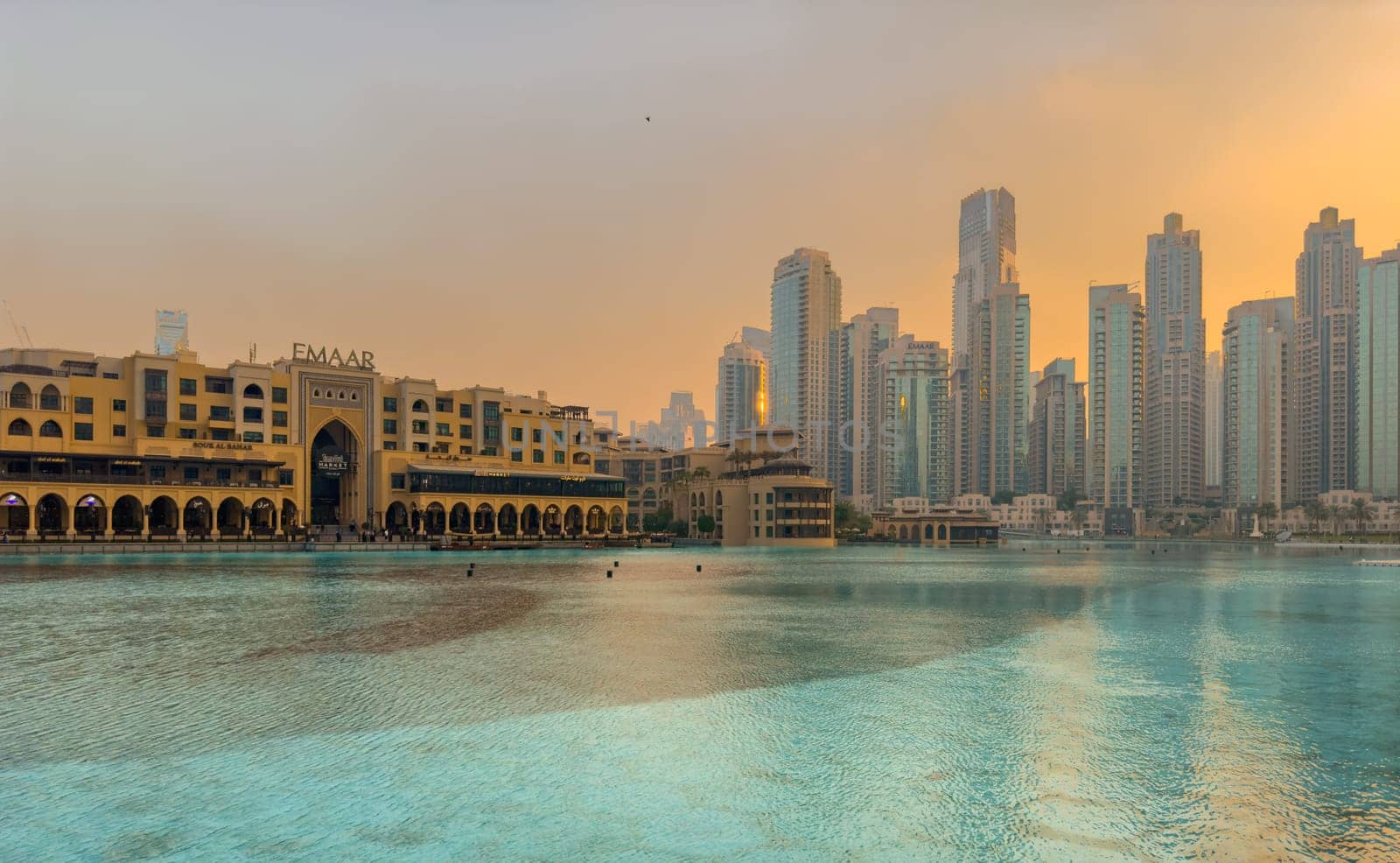 UAE, Dubai, 26 September 2024: The famous shopping center Dubai Mall and Burj Khalifa skyscraper at dusk, Dubai's sights and skyscrapers illuminated at night, palm trees. High quality photo
