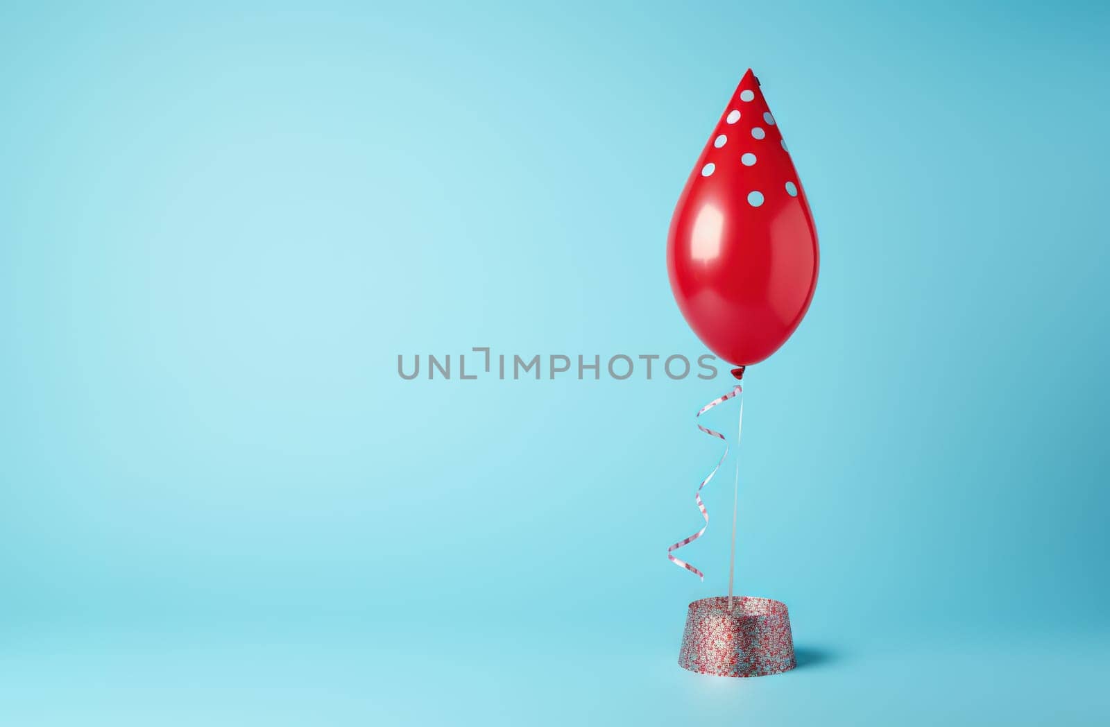 Red birthday balloon wearing cone carnival hat for celebration with confetti on the blue background. Generated AI