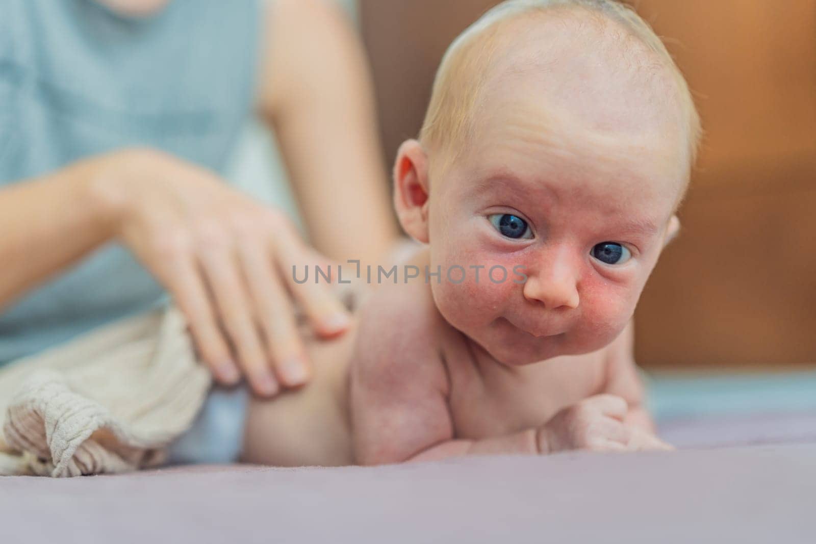 A mother gently massages her 1-month-old baby with baby oil after a bath. This tender moment highlights the bond between parent and child, promoting relaxation, baby care, and the importance of skin-to-skin contact.