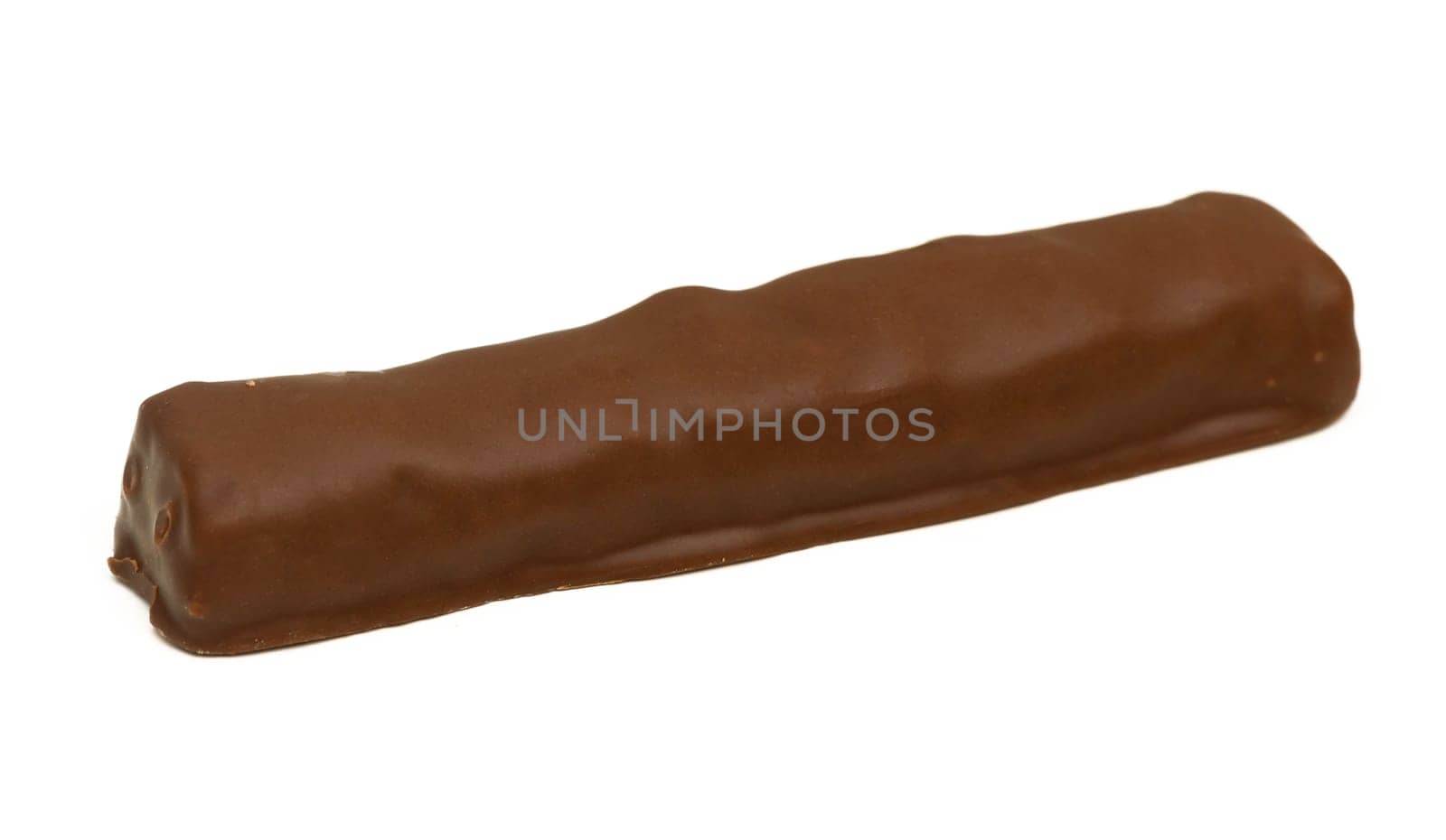 A rich chocolate bar lies on a clean white surface, showcasing its smooth, glossy coating in natural light.