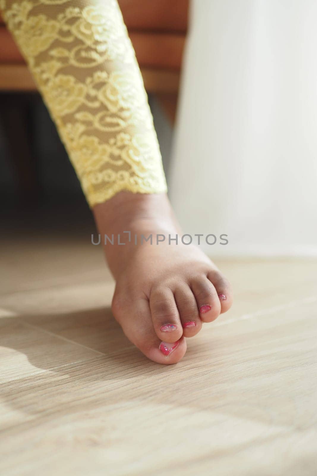 A child is stepping forward, showcasing a colorful outfit and playful energy.