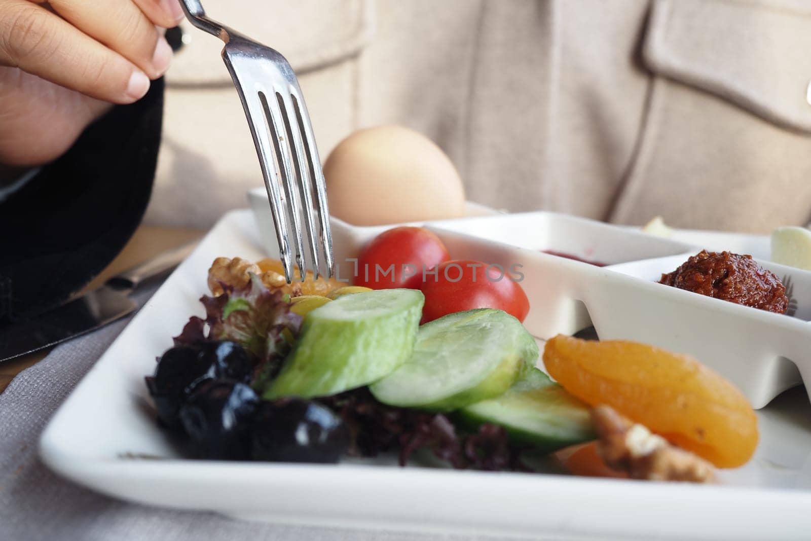 A person enjoys a vibrant plate full of fresh vegetables and fruits.