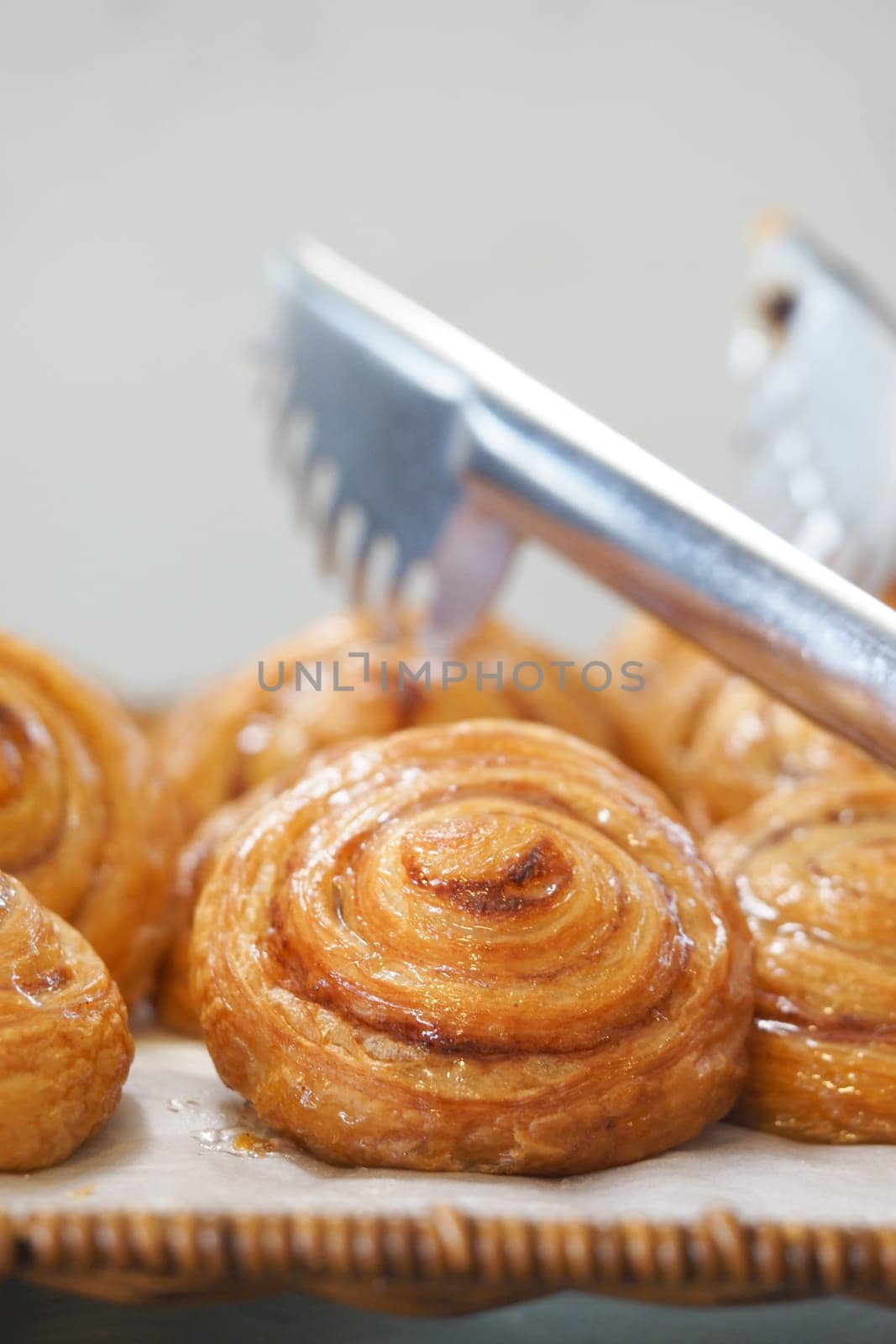 Delicious cinnamon rolls glisten with glaze on a decorative tray.