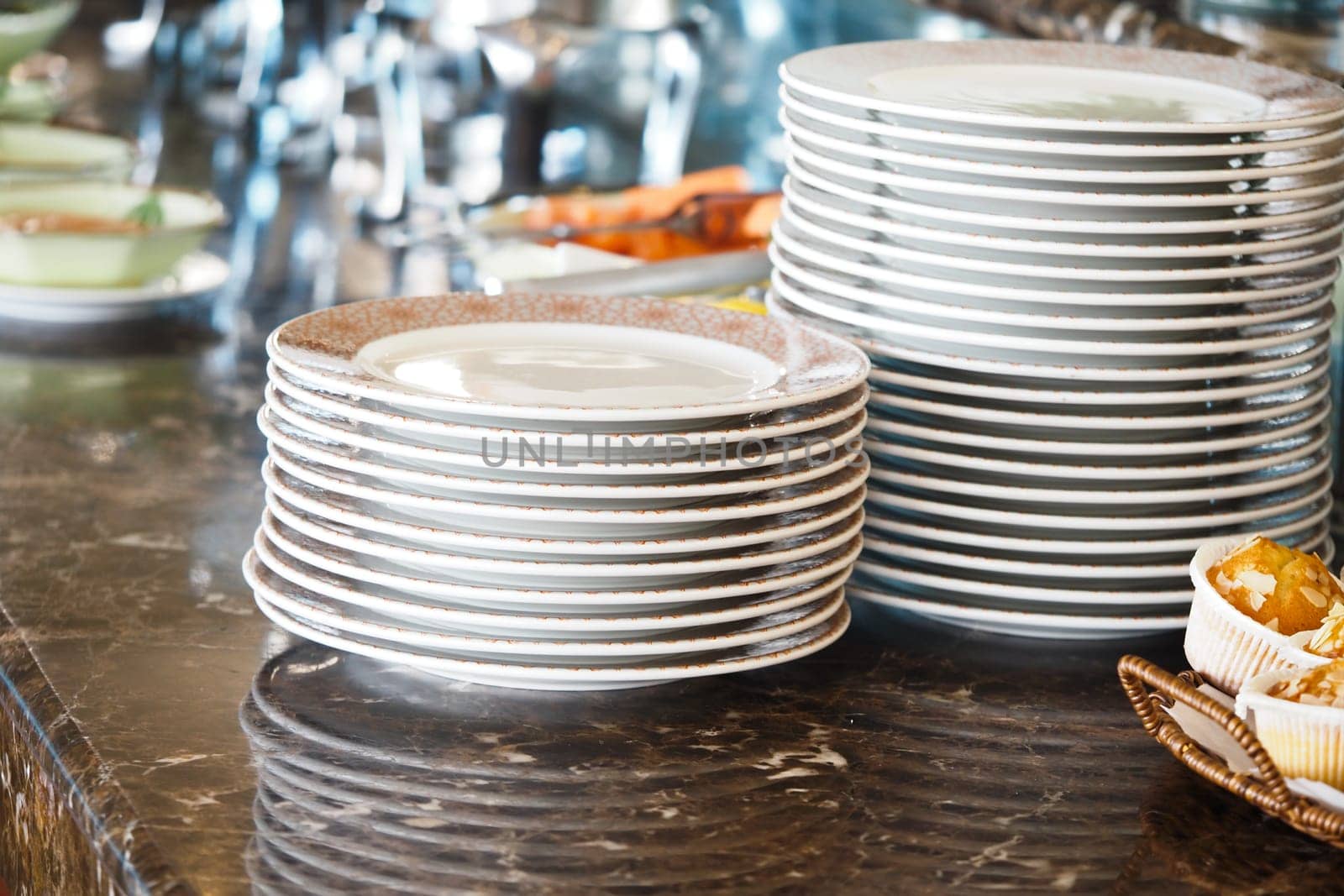 Stacked plates await customers in a bustling dining establishment.
