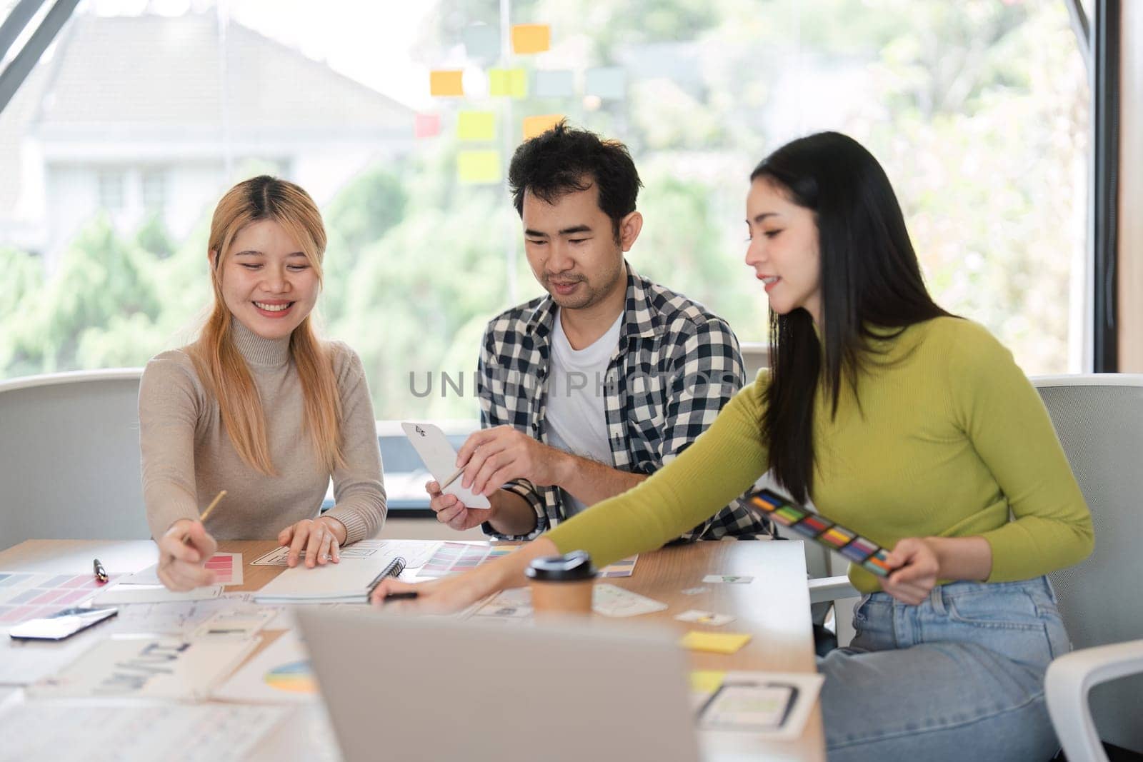 A diverse team of professionals collaborating on creative concepts and planning while sharing ideas at a bright office workspace.