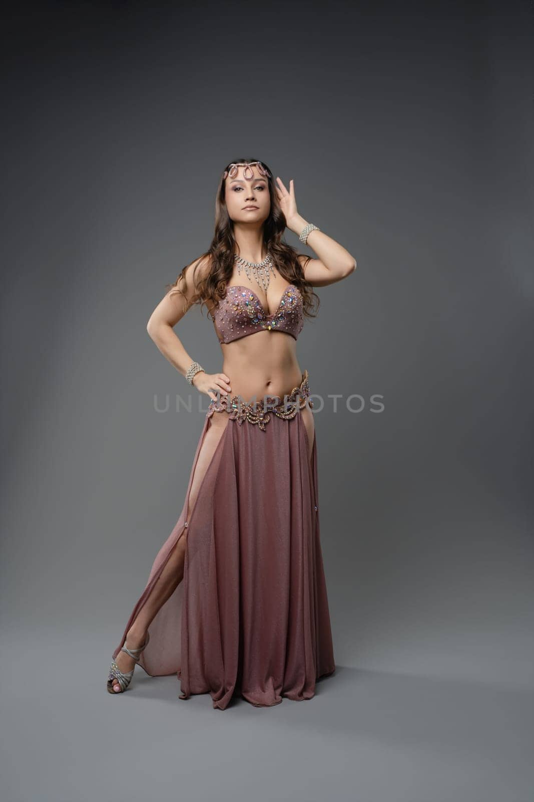 A skilled dancer showcases her talents in a stylish costume, blending traditional and modern elements in a dance studio.