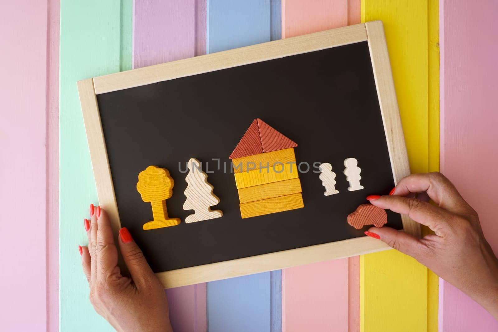 Women's hands lay out figures made of cubes on the board. High quality photo