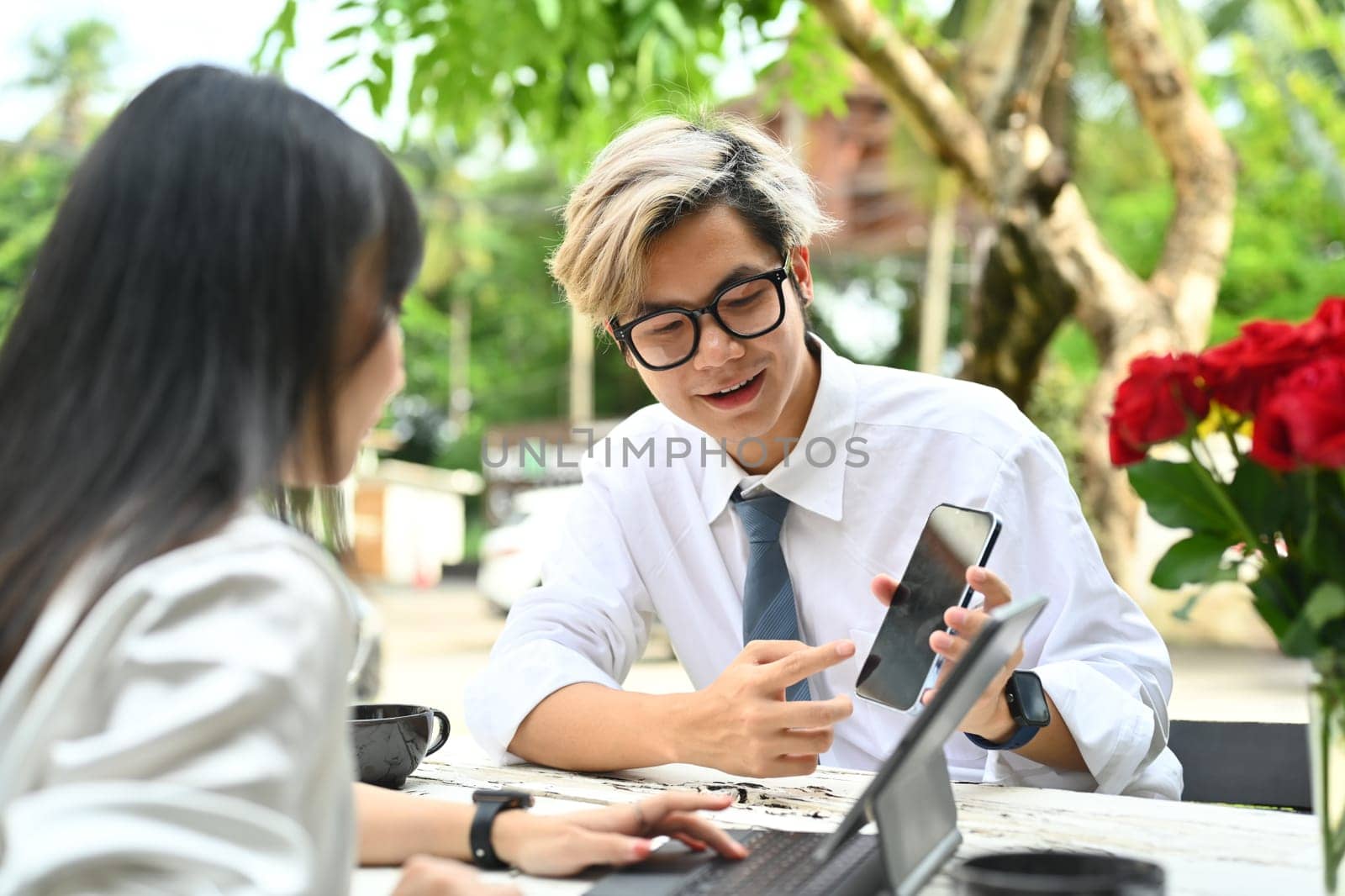 Smiling male realtor or financial advisor consulting young female clients about buying, renting house by prathanchorruangsak