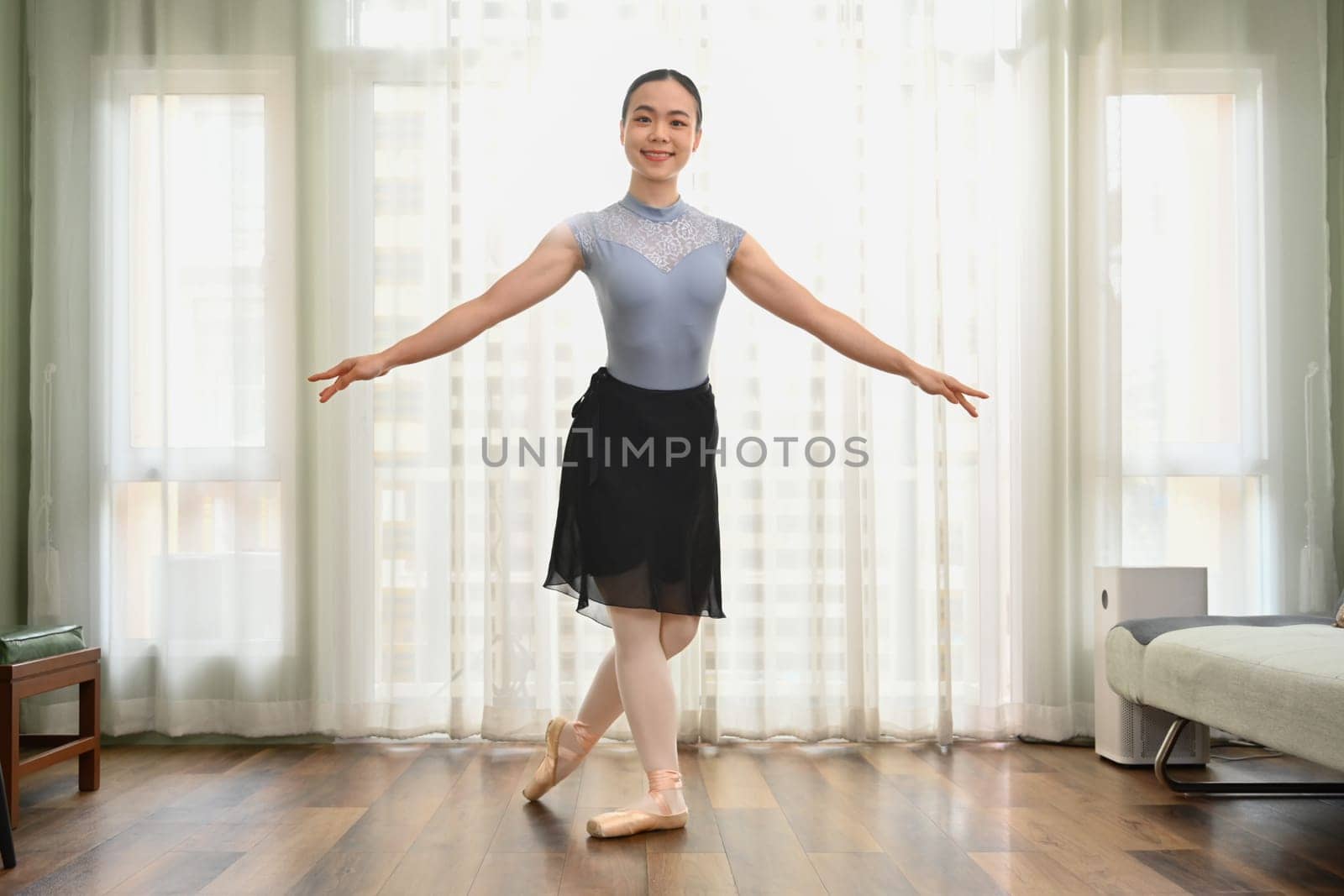 Full length portrait of beautiful woman practicing ballet at home. Dance, art and active lifestyle concept by prathanchorruangsak