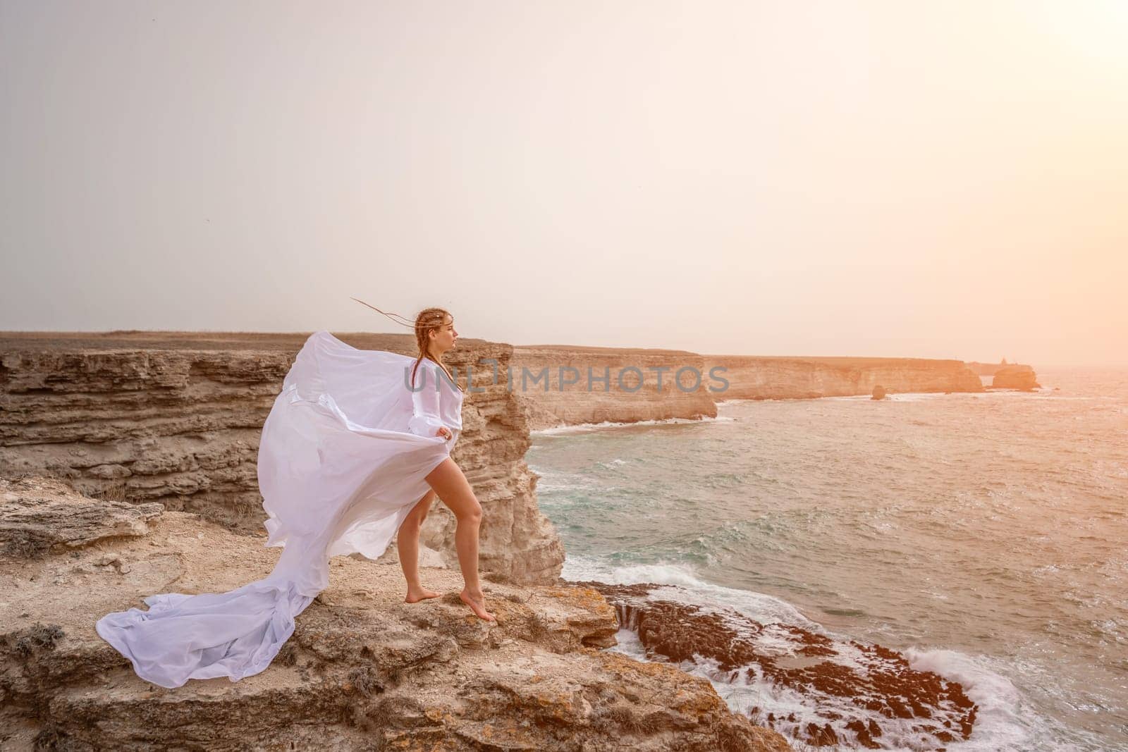 Woman sea white dress. Happy freedom woman on the beach enjoying and posing in white dress. Rear view of a girl in a fluttering white dress in the wind. Holidays, holidays at sea. by Matiunina