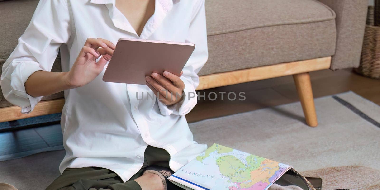 Young traveler woman using laptop to book a hotel and search for tourist attraction information while prepare travel suitcase before going on summer vacation. Online booking concept by nateemee