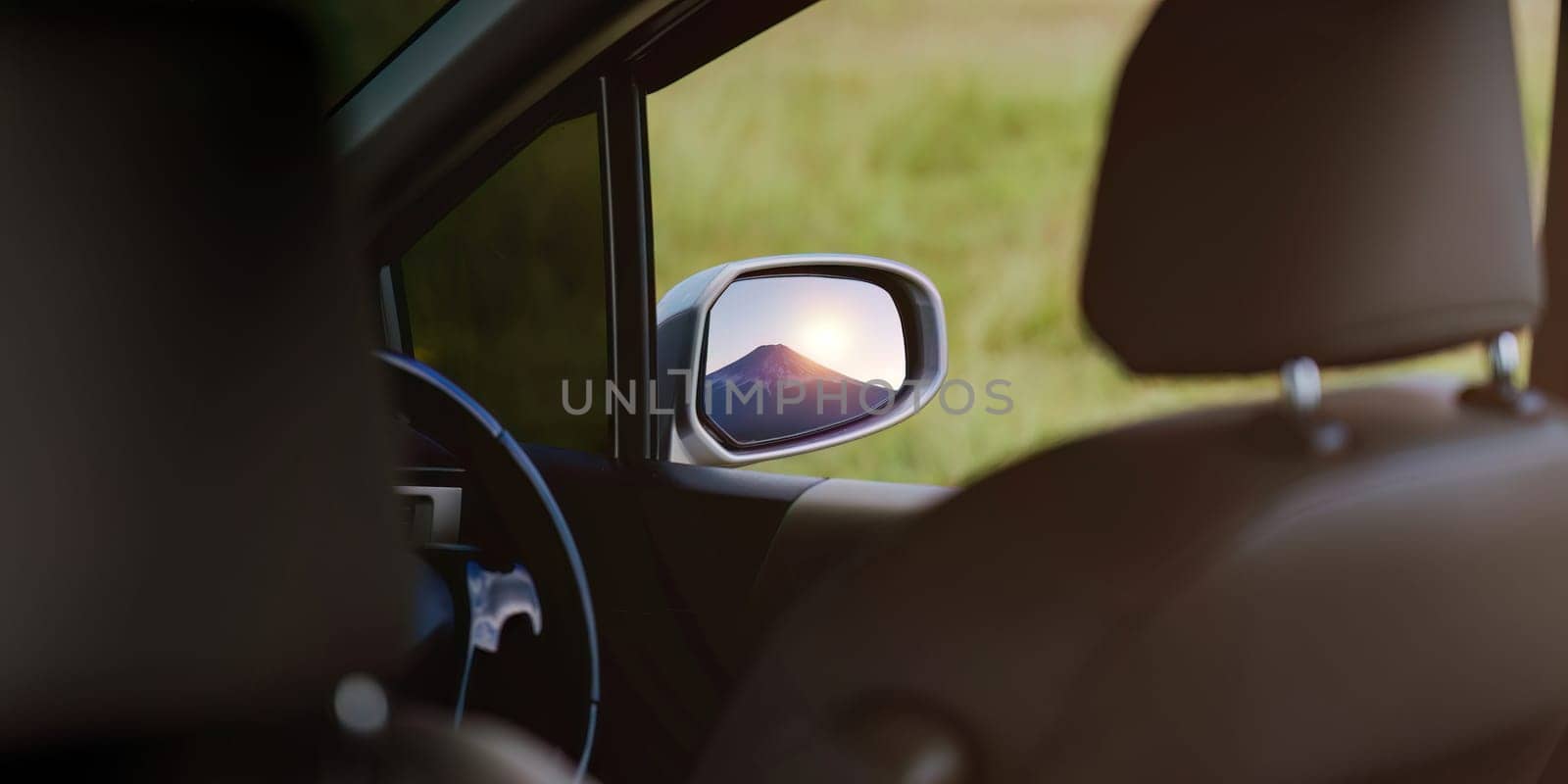 Reflection of a gorgeous Mount Fuji in a side mirror of a car while parking to take photos concept travelling driving rest.