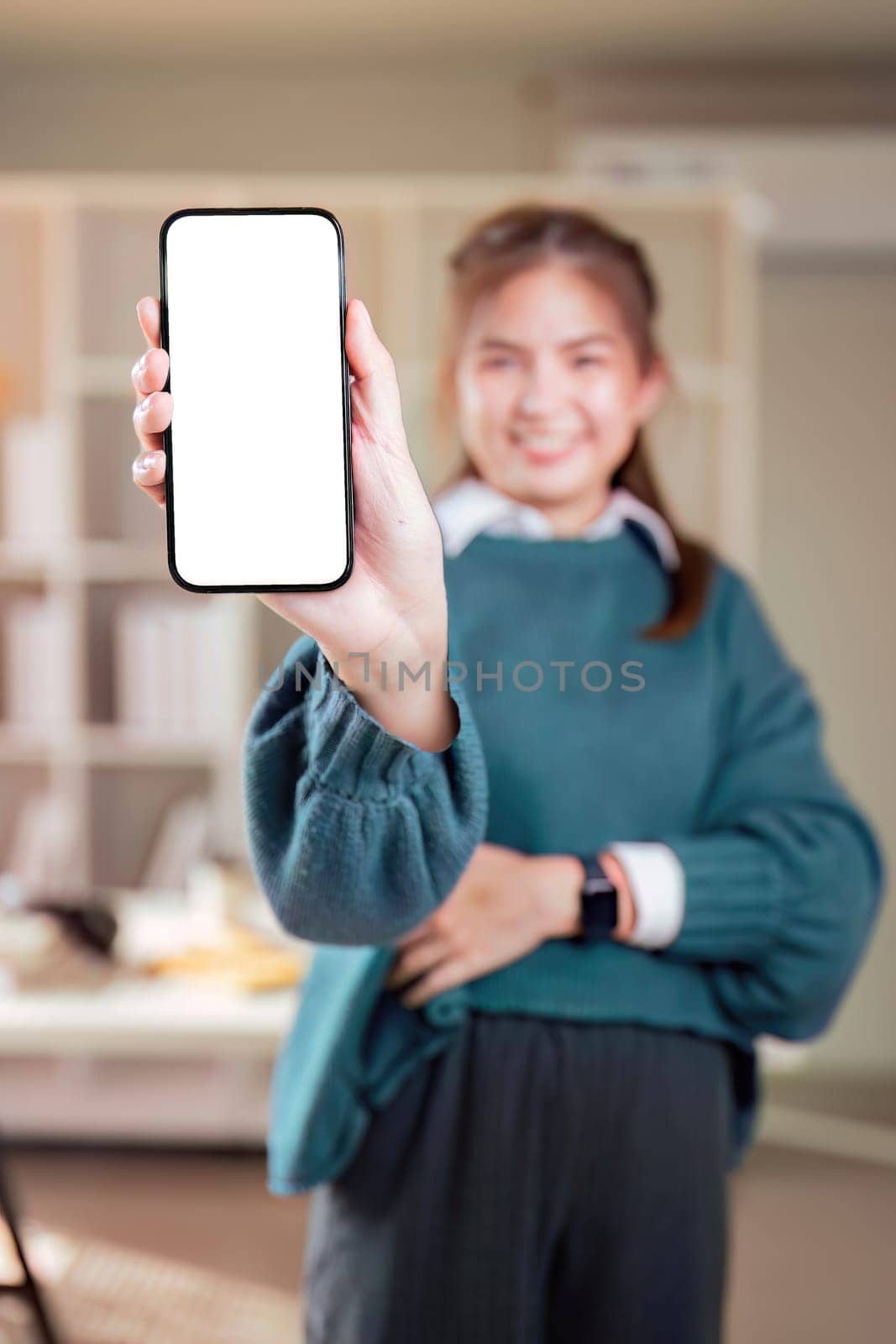 Joyful asian woman, showing mockup her smartphone with empty white mockup screen, rejoices in success, looks at camera, make YES gesture.