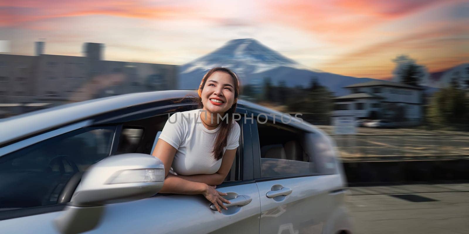 Cheerful female friends going on a trip while woman friends sticking head out of car in motion to see the view in japan by nateemee
