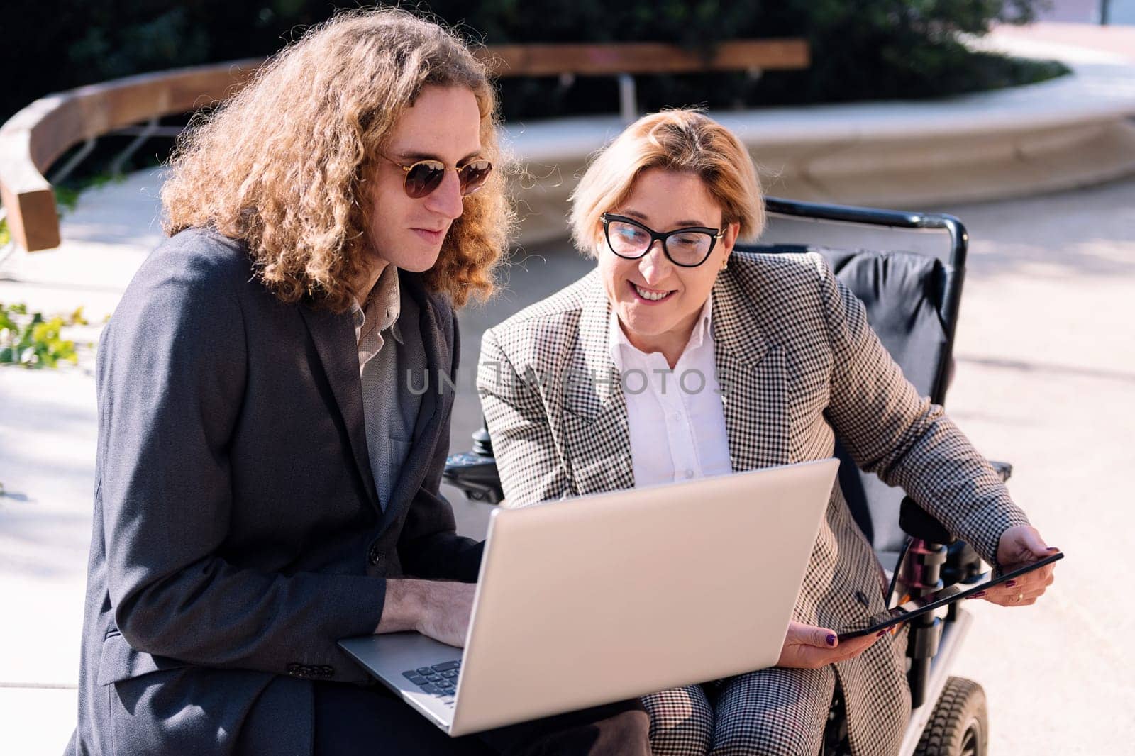 businessman and woman working outdoors with laptop by raulmelldo