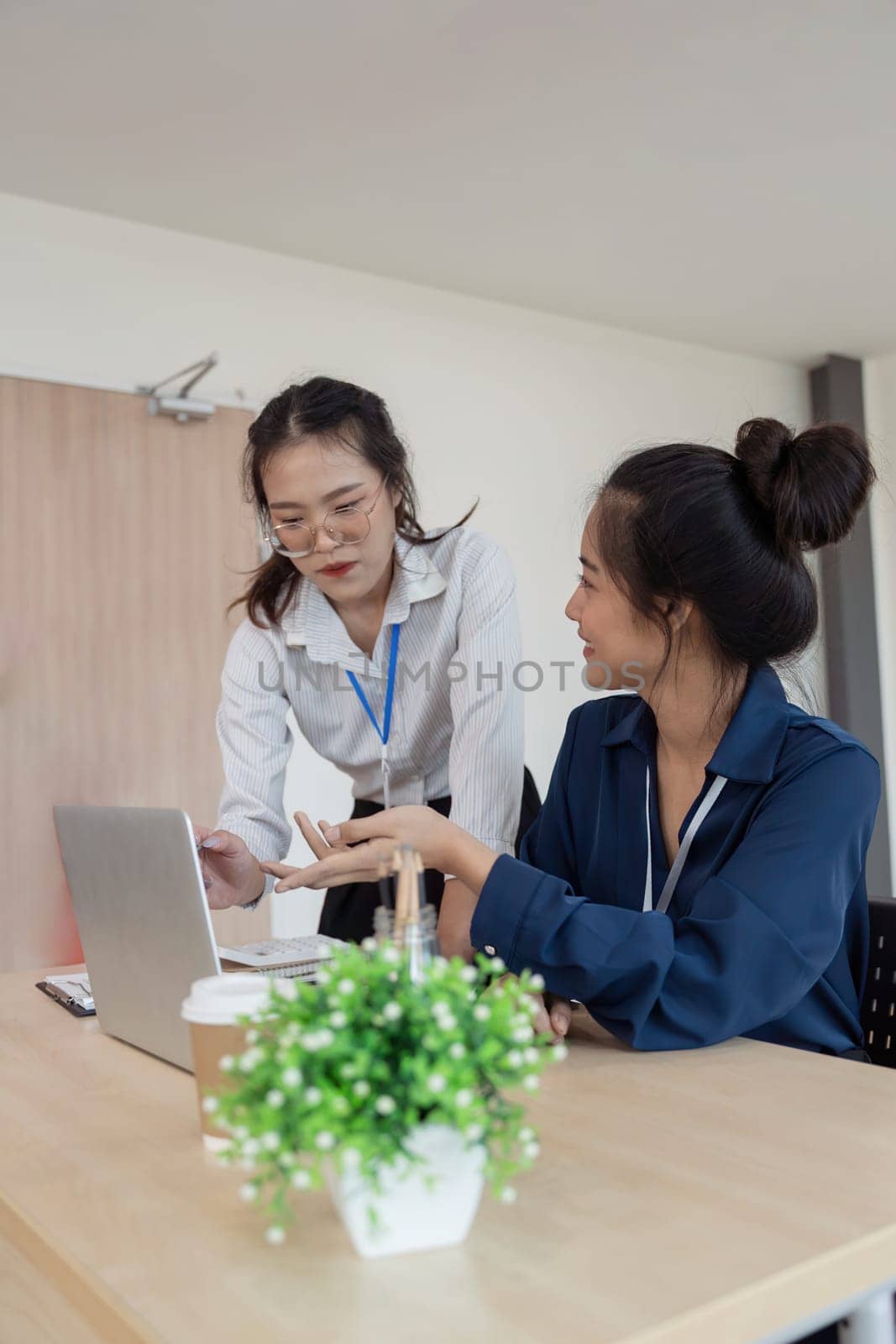 Teamwork of business two colleague analysis with financial data and marketing report graph, Young business woman two co worker discuss for calculating financial document.