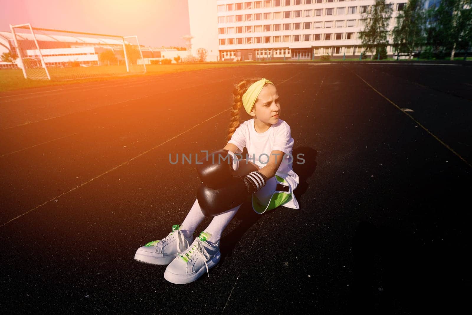 Female child boxer in gloves, feminism concept. Back to school, physical training.