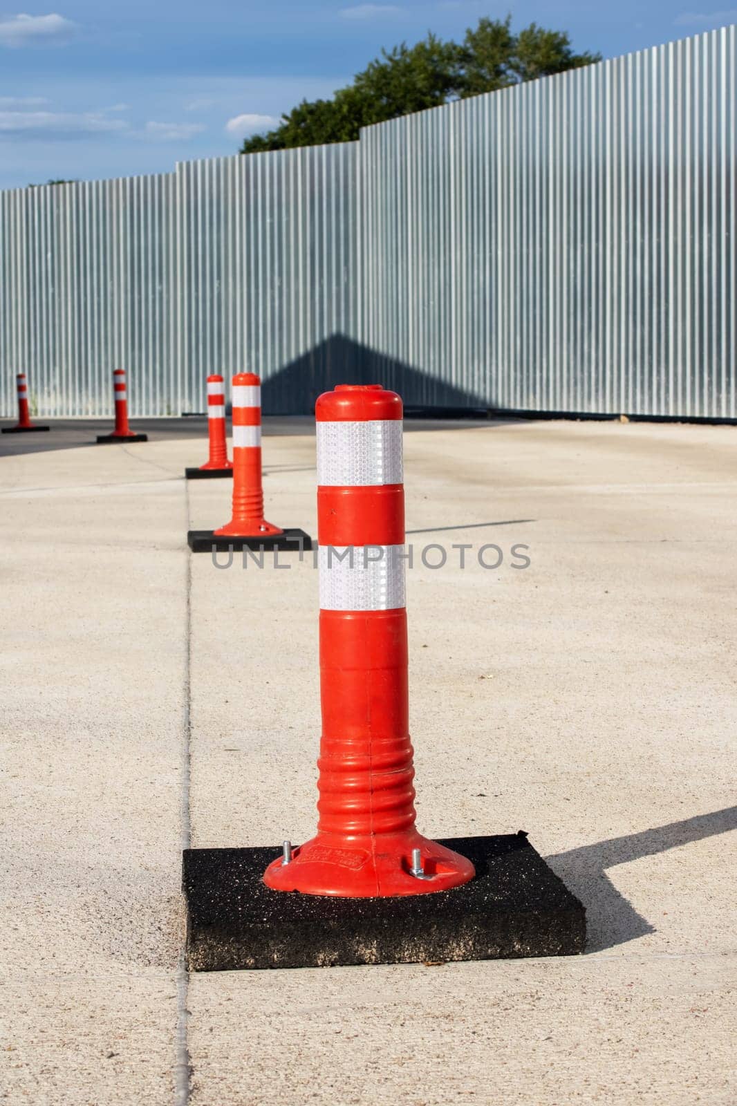 Orange restrictive poles on the road close up