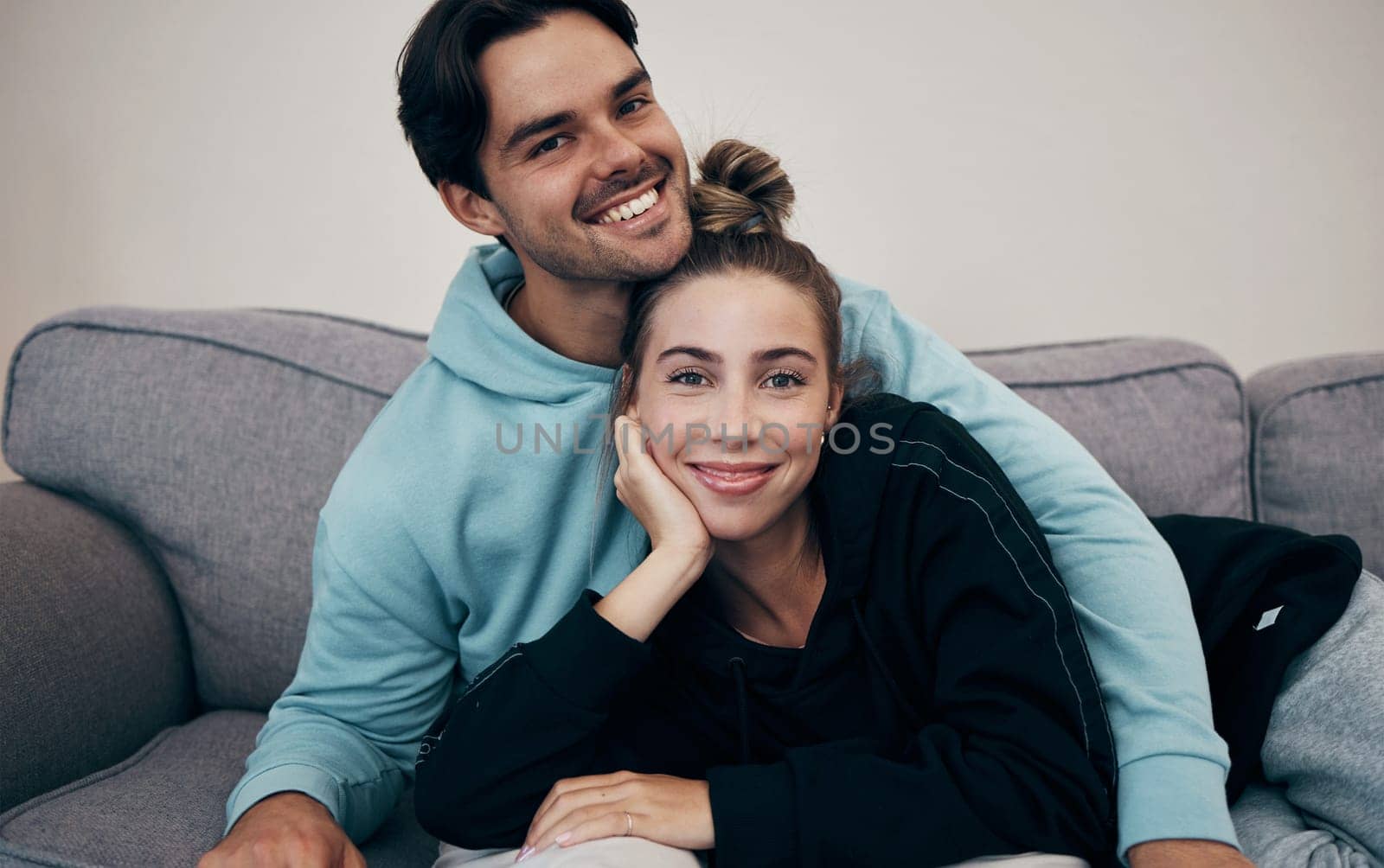 Portrait, love and smile with a couple on a sofa in the living room of their home together for bonding. Relax, hug or date with a happy man and woman in their apartment for romance or relationship.