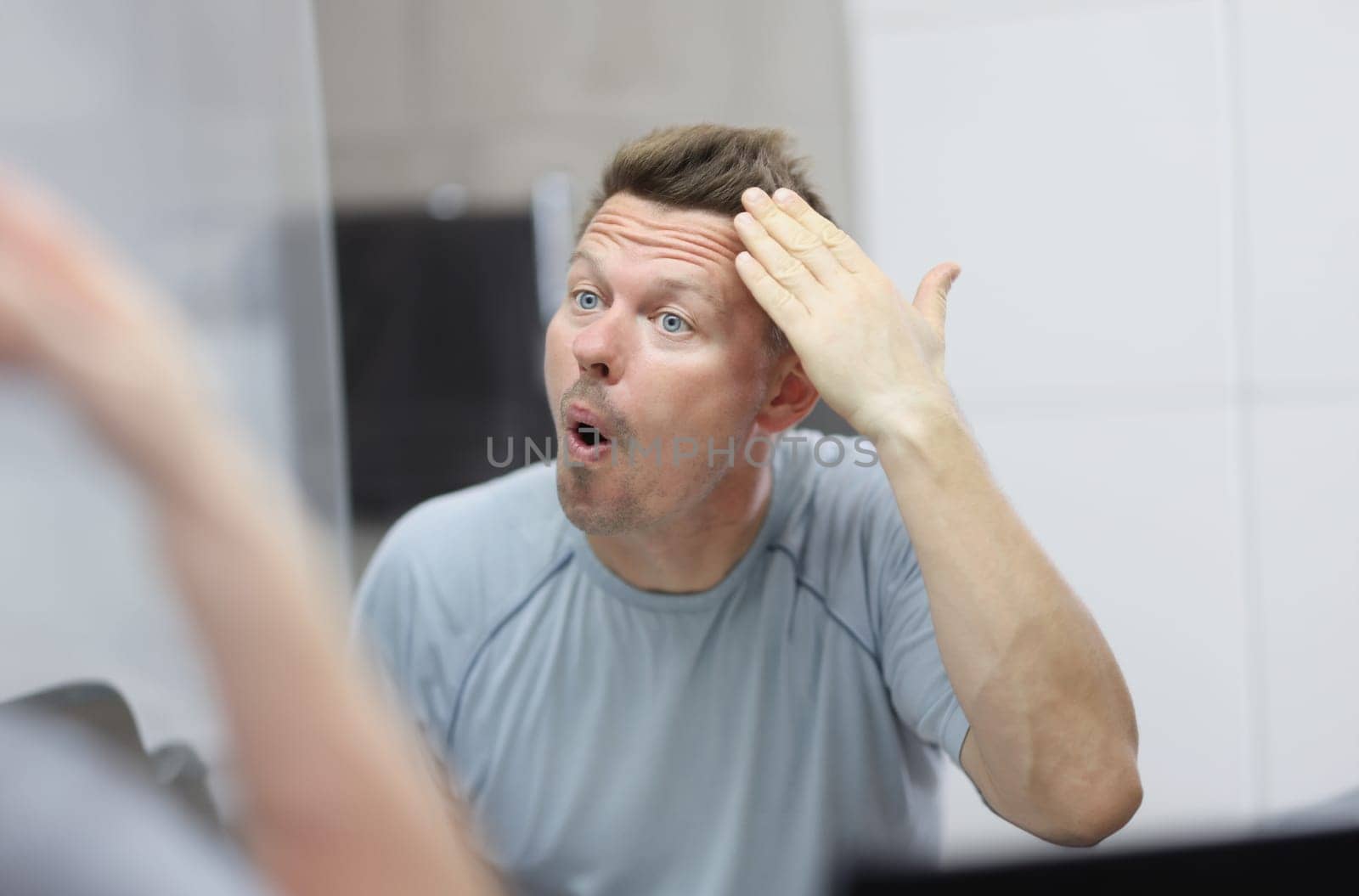 Narcissistic man in front of mirror does his hair by kuprevich