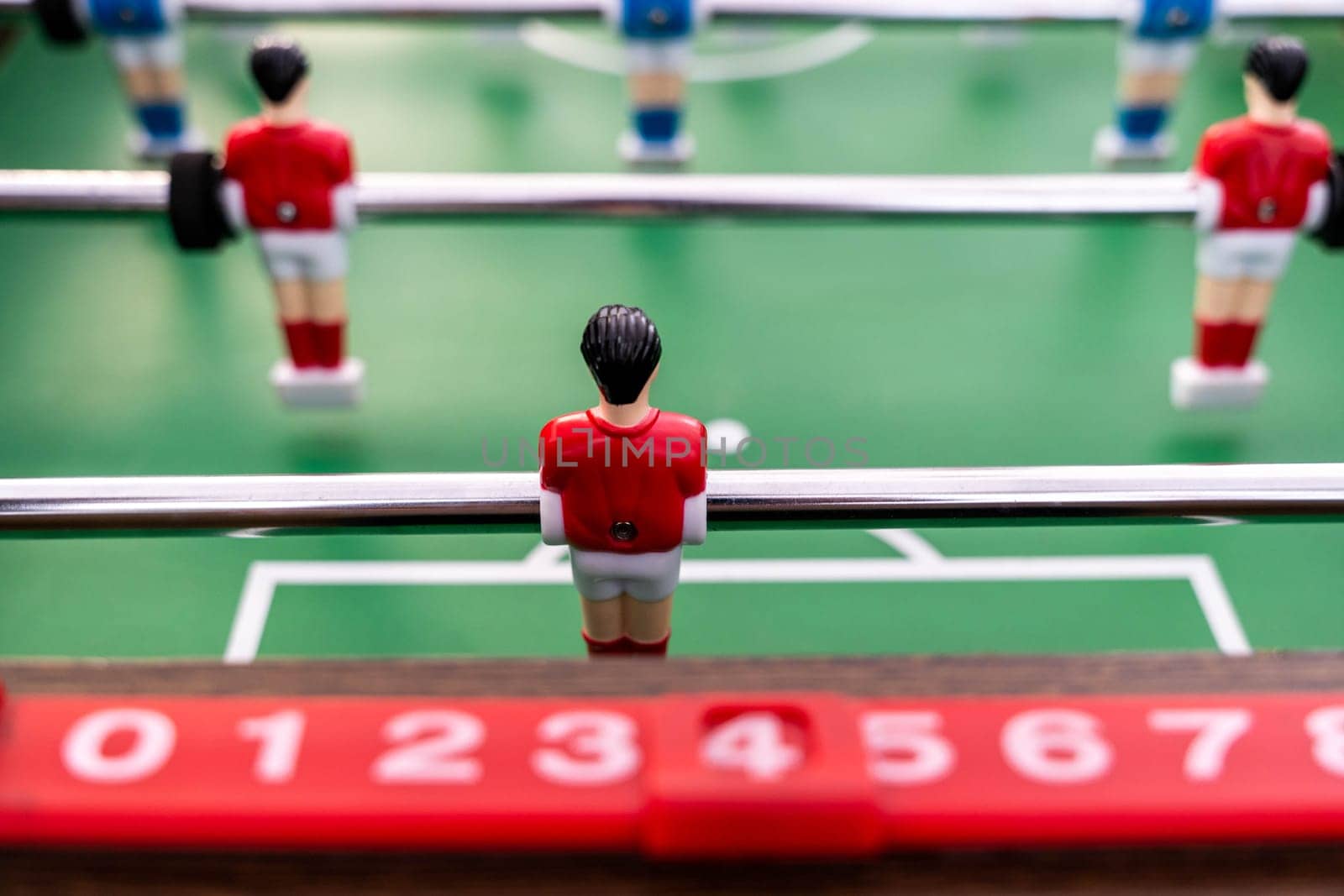 Table football. Close-up of figures of plastic players in a football match. red and blue players kick the ball.