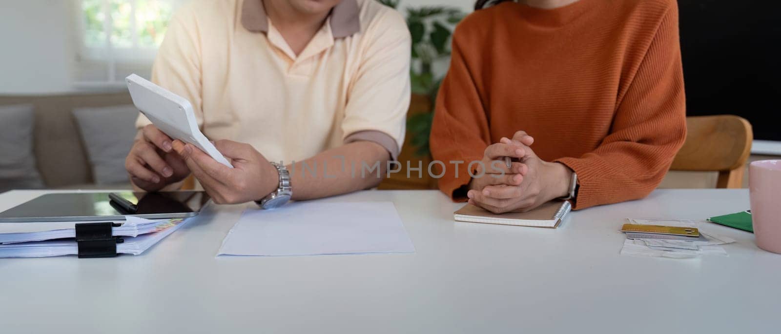 A couple analyzes financial documents and discusses strategies for managing their income and expenses effectively.
