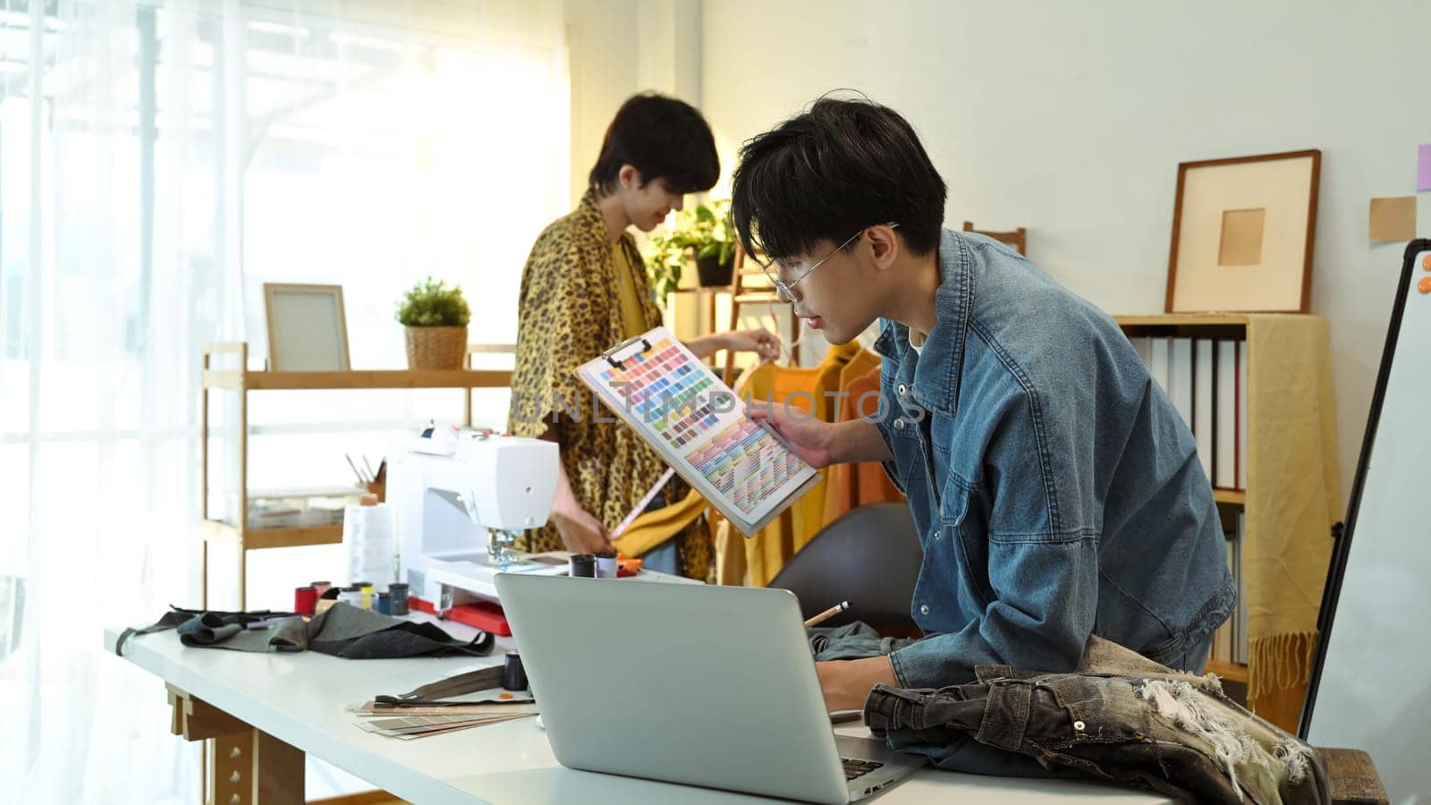 Team of fashion designers collaborating on new project in a studio.
