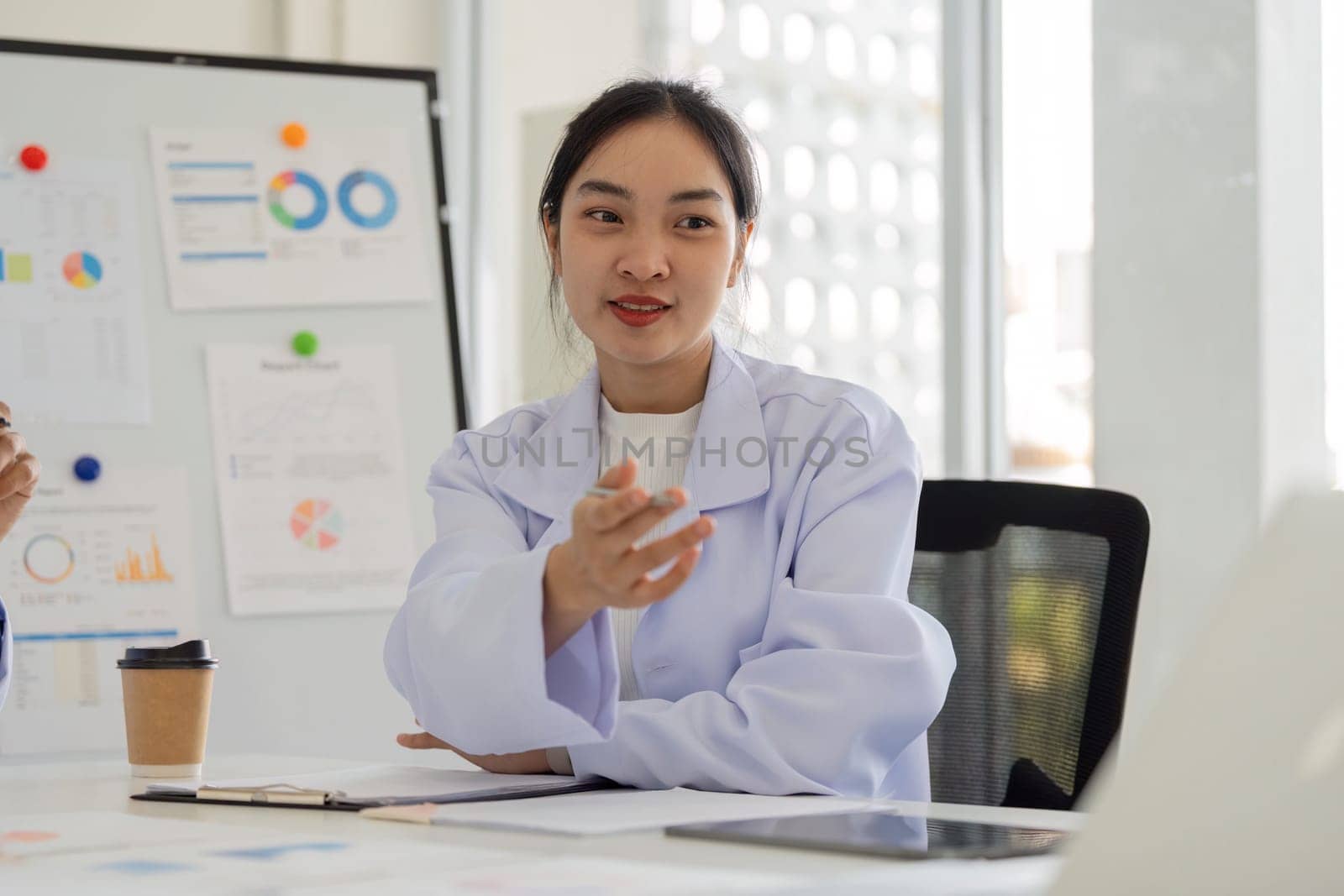 A physician shares insights and strategies during a meeting with healthcare professionals, focusing on data analysis and teamwork.