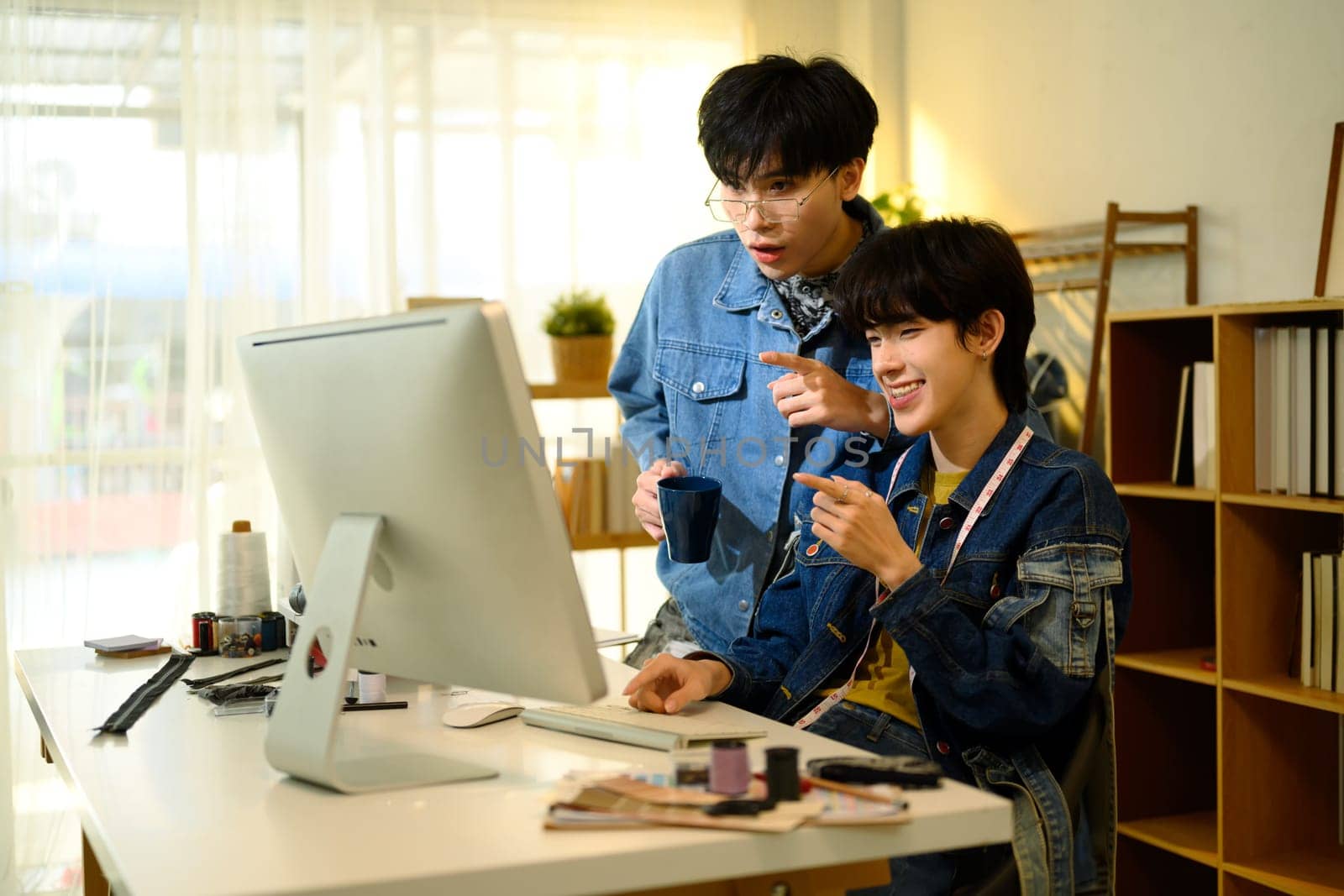Team of fashion designers collaborating on new project in a studio.